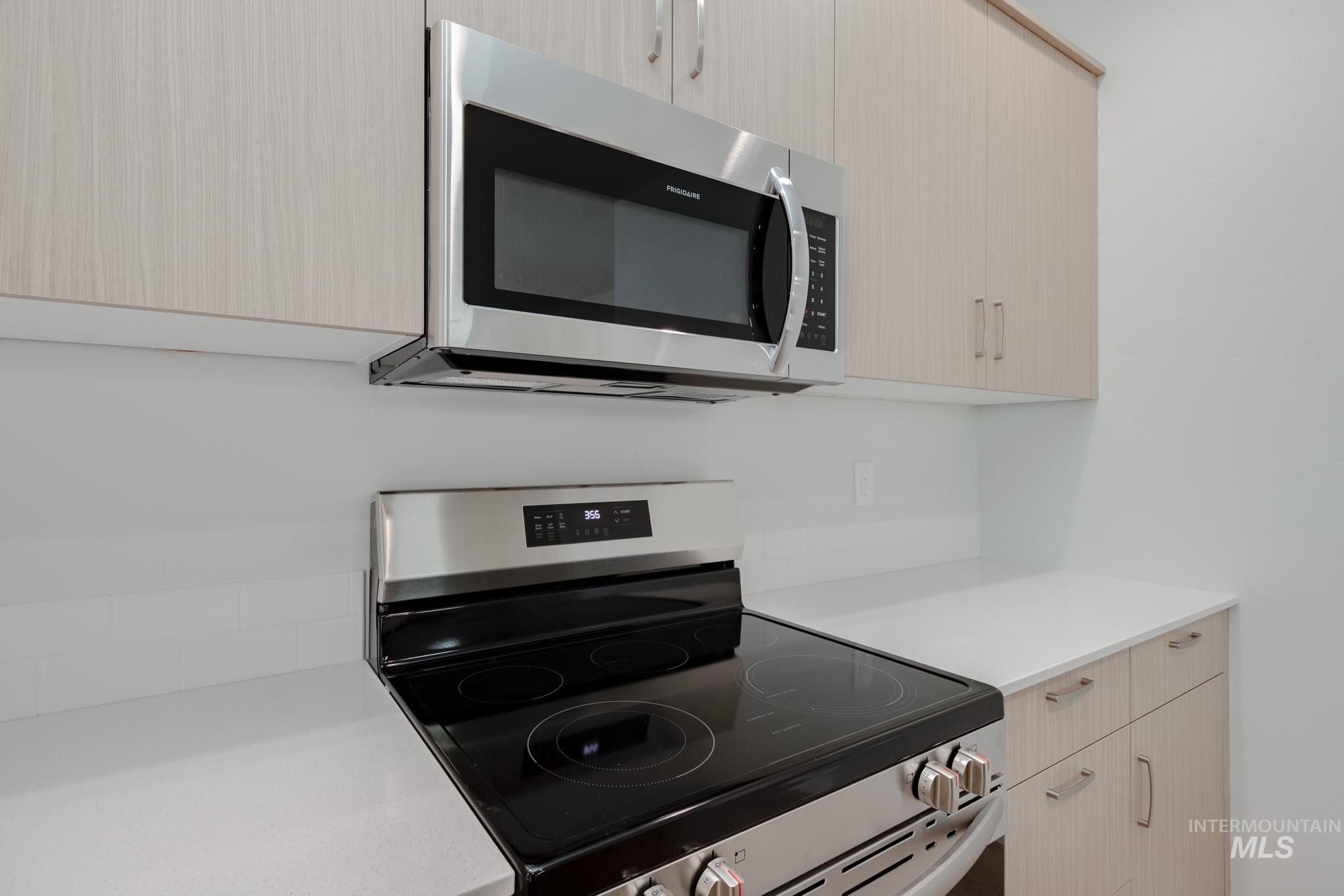 Kitchen featuring stainless steel appliances, modern cabinets, and light brown cabinetry