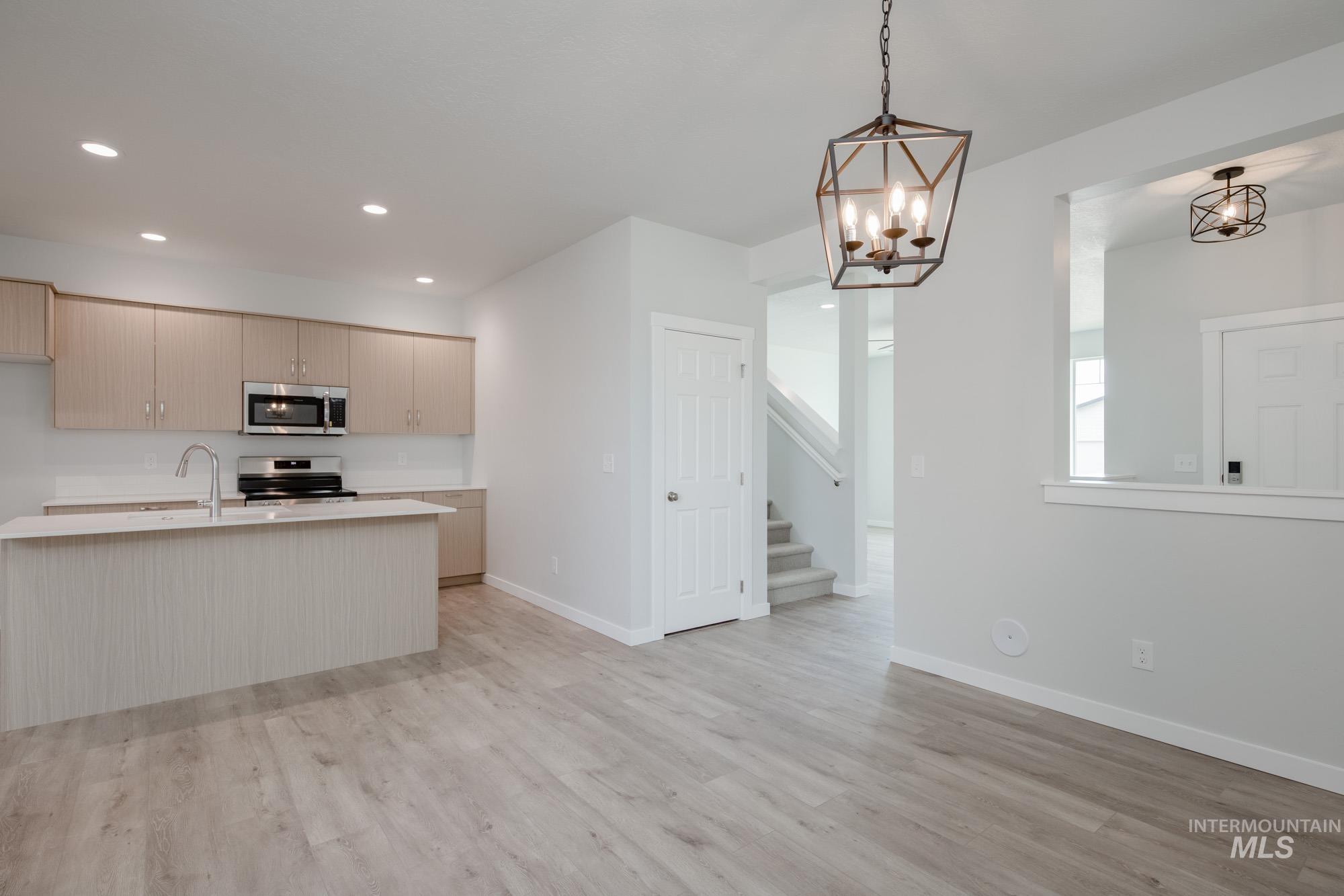 Kitchen featuring pendant lighting, stainless steel appliances, light wood-style floors, modern cabinets, and recessed lighting