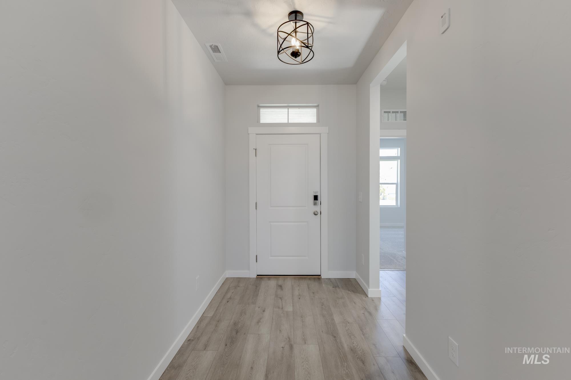 Entryway with baseboards and light wood-type flooring