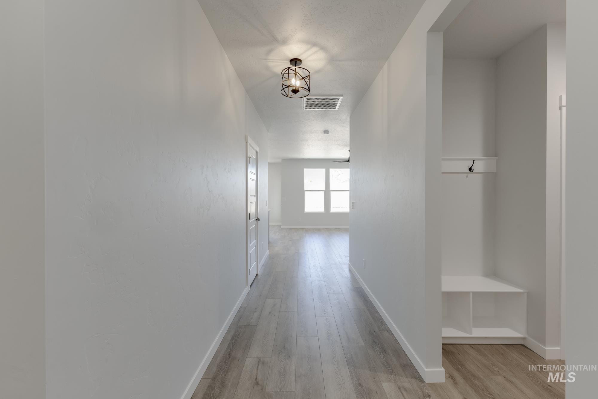 Hall with light wood-style floors and baseboards