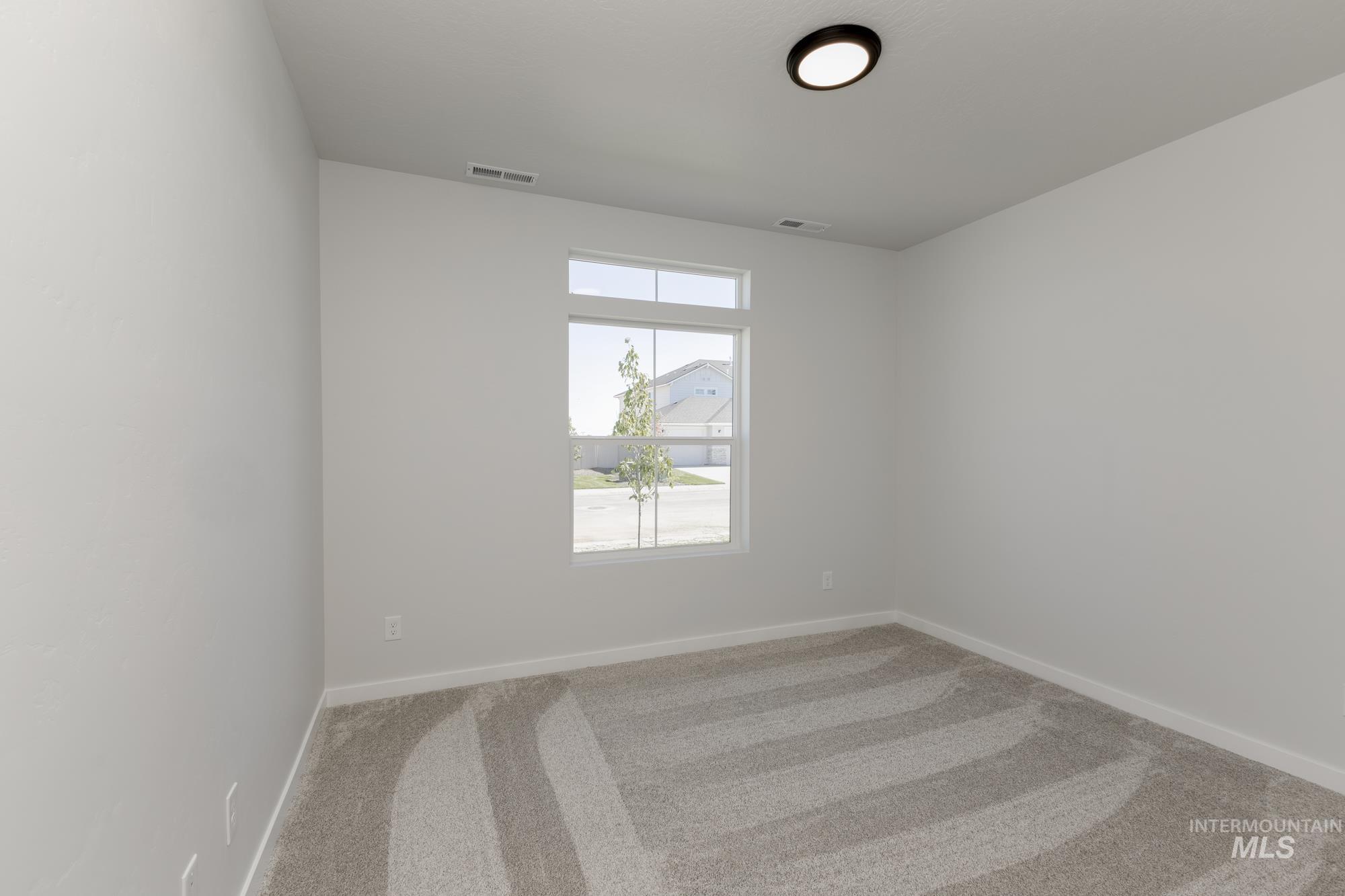 Unfurnished room featuring light carpet and baseboards