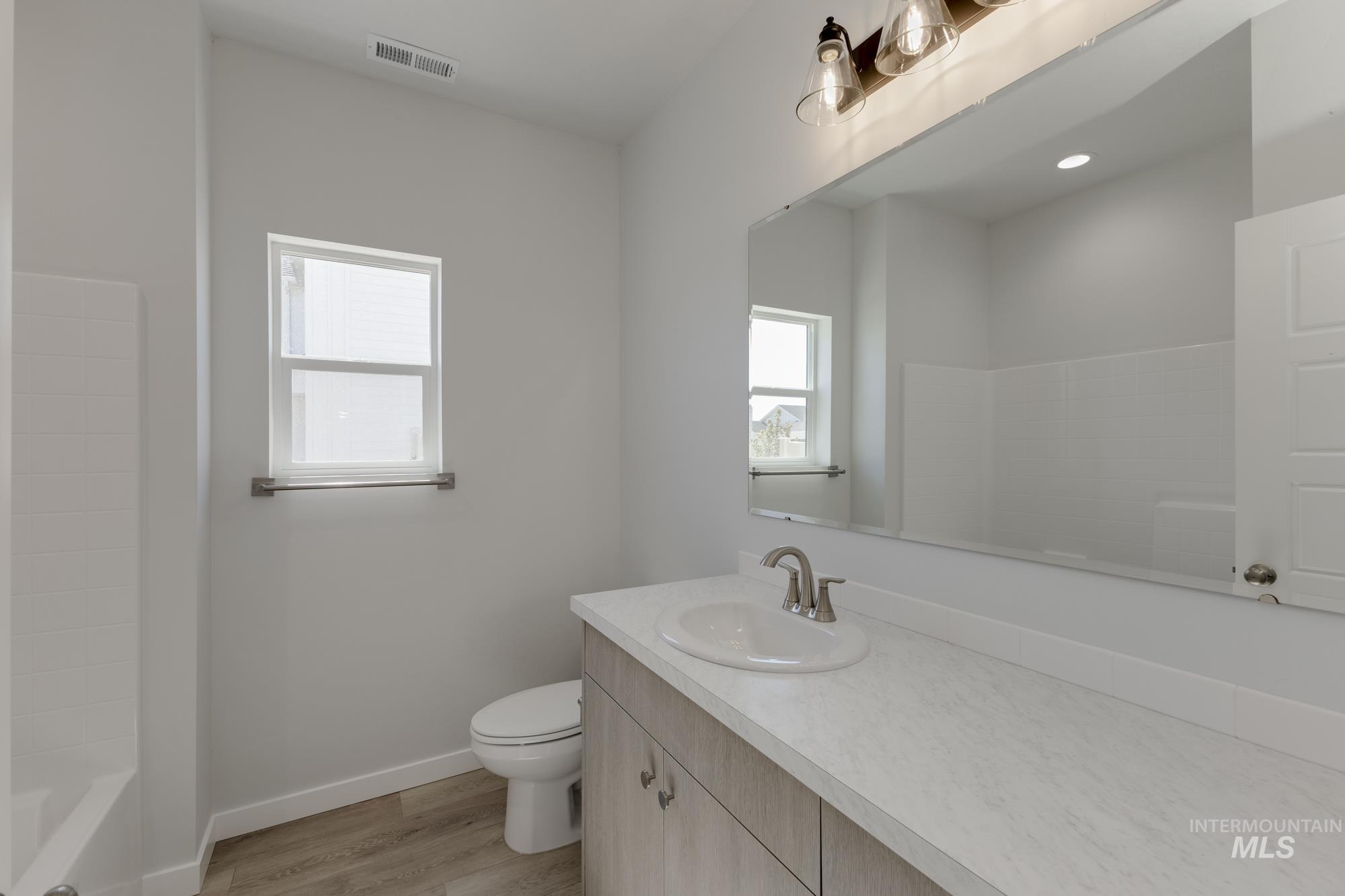 Bathroom featuring vanity, light wood finished floors, and bathtub / shower combination