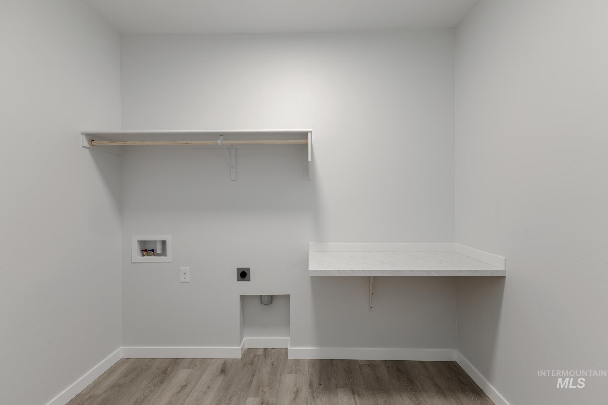 Laundry room with light wood-type flooring, hookup for an electric dryer, and hookup for a washing machine