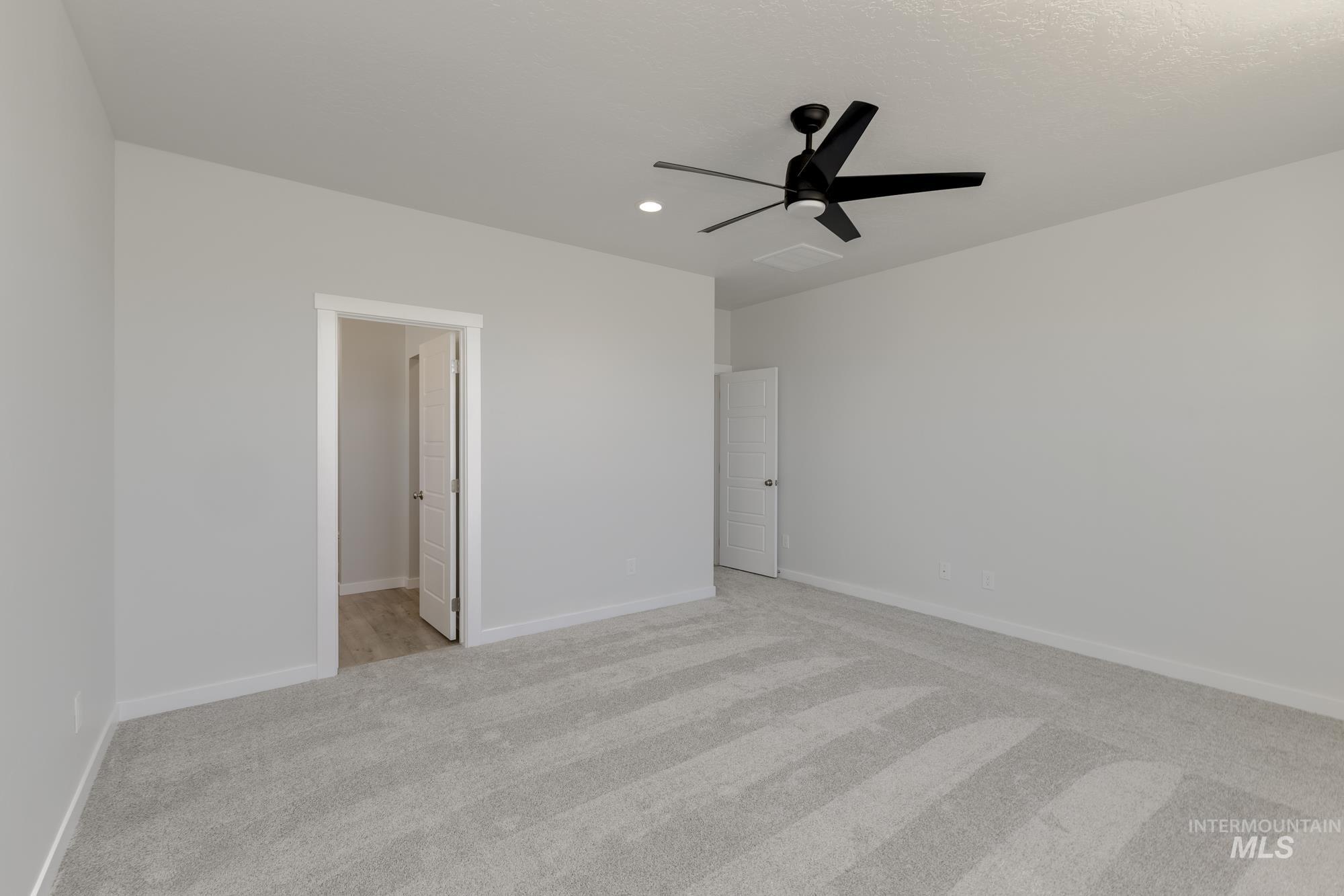 Unfurnished bedroom featuring light colored carpet, ceiling fan, and recessed lighting