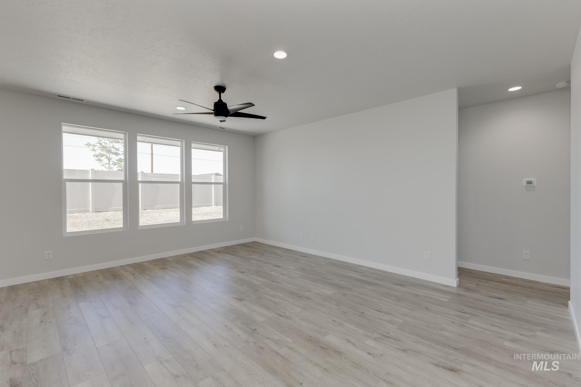 Empty room with light wood-type flooring, recessed lighting, and a ceiling fan