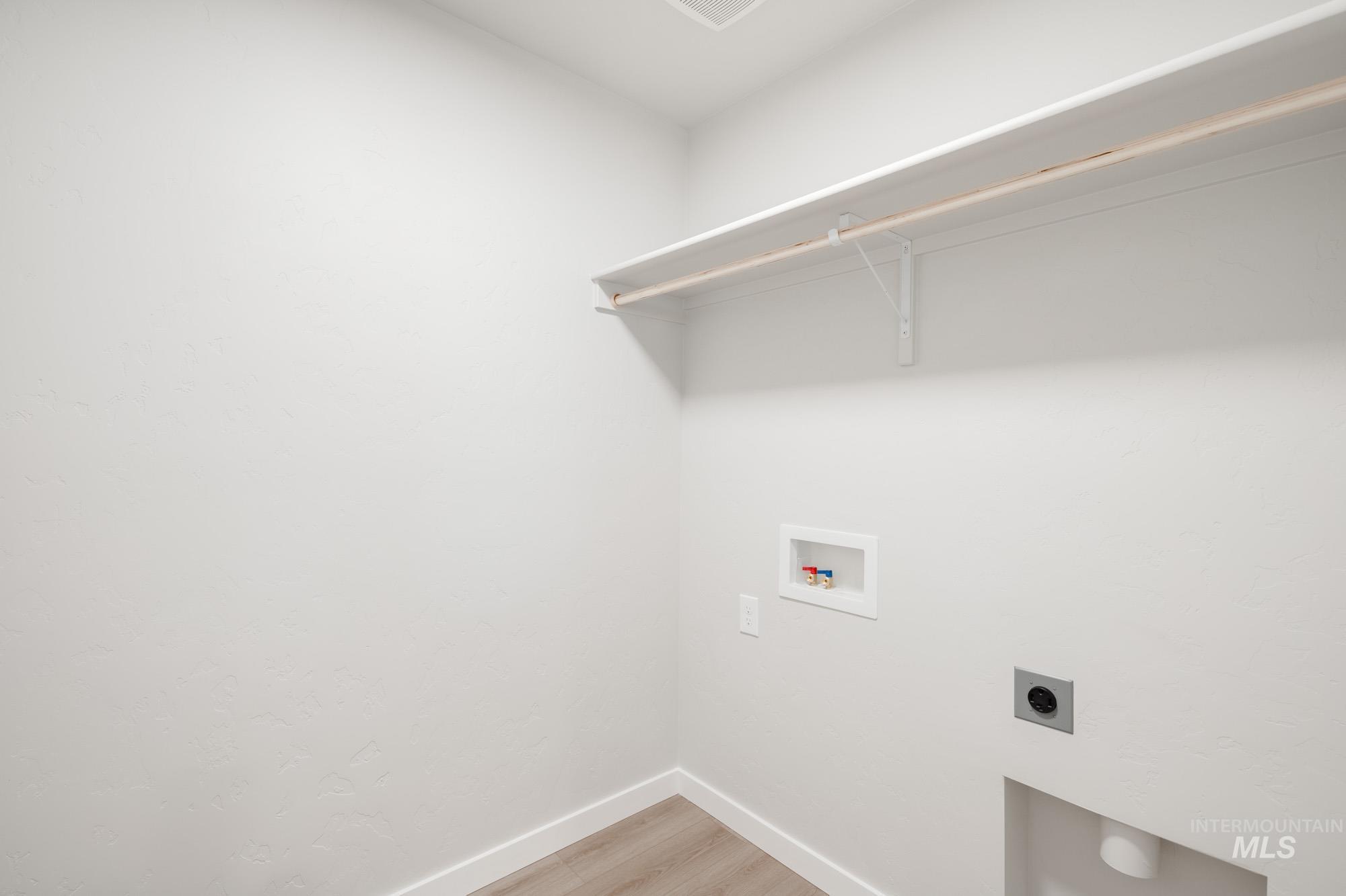 Laundry room featuring light wood-style flooring, electric dryer hookup, and hookup for a washing machine