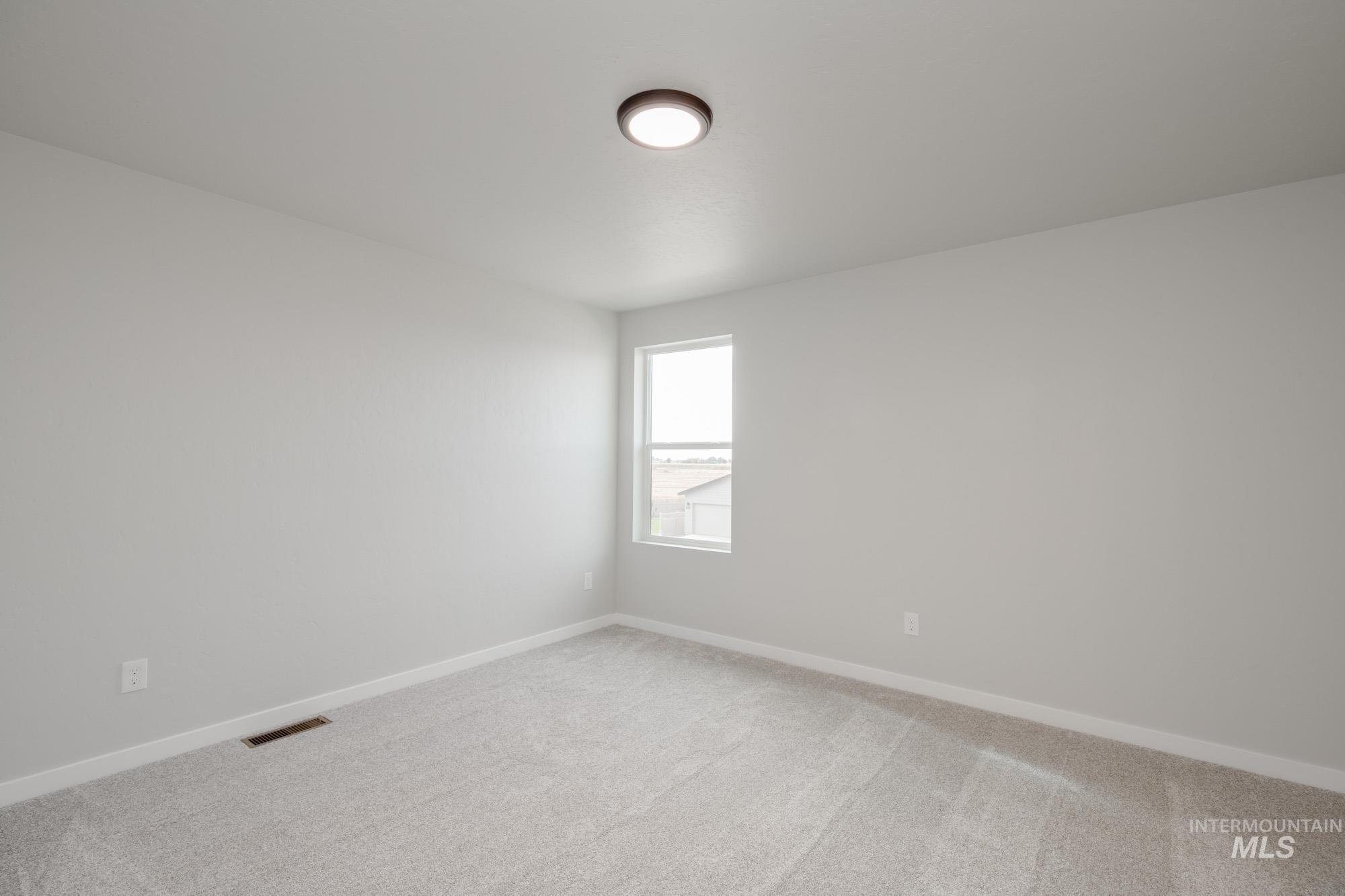 Empty room with light carpet and baseboards