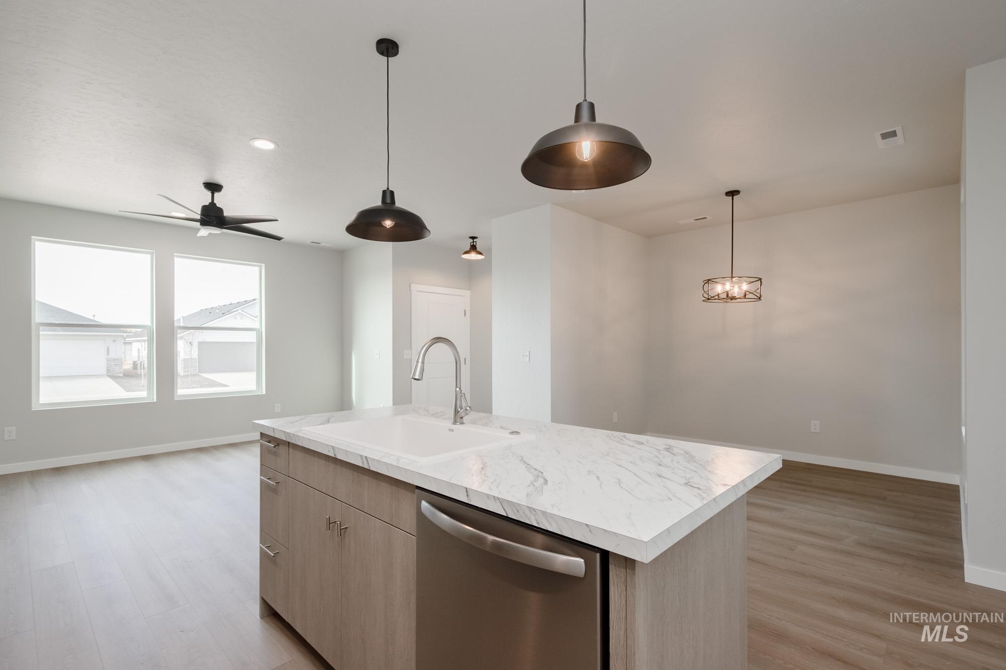 Kitchen with light countertops, dishwasher, ceiling fan, open floor plan, and light wood-type flooring
