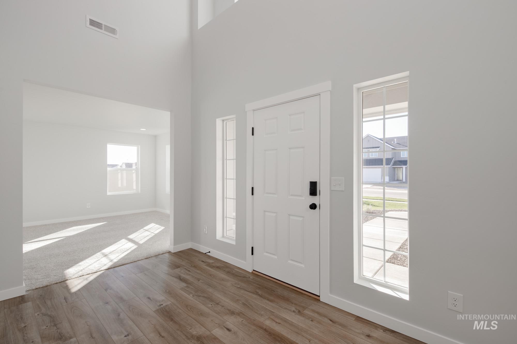 Entrance foyer featuring light wood-style floors and a high ceiling
