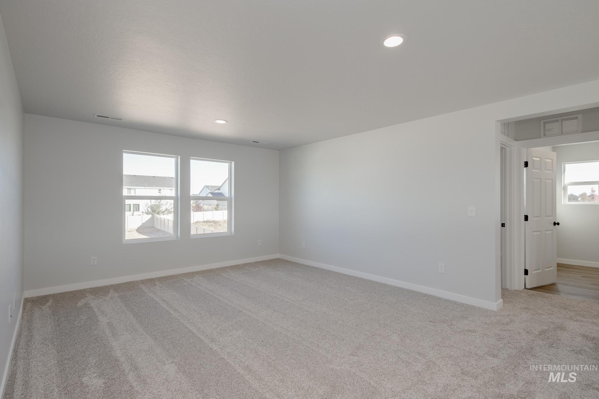 Spare room featuring light colored carpet and recessed lighting