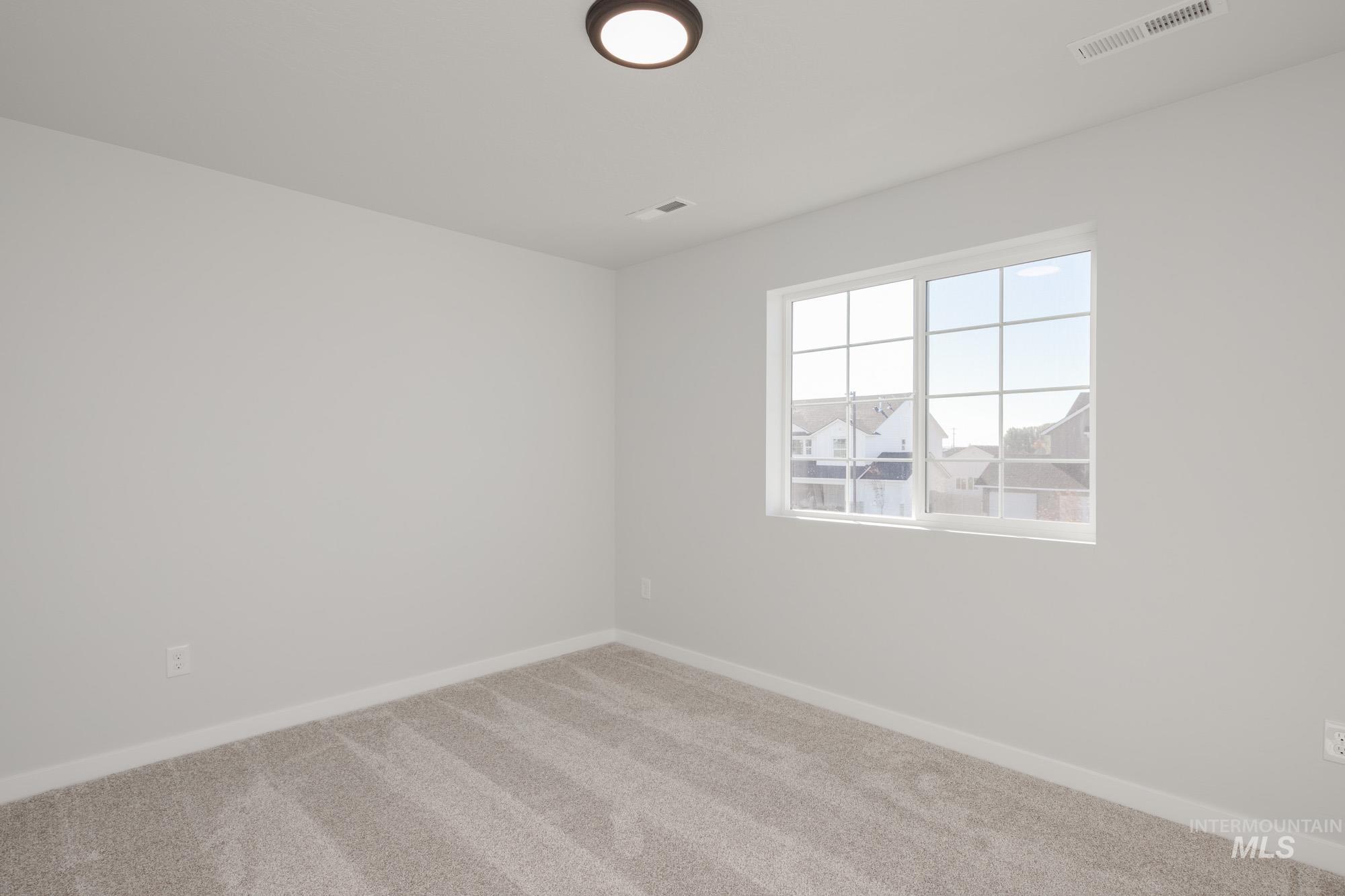 Carpeted empty room featuring baseboards