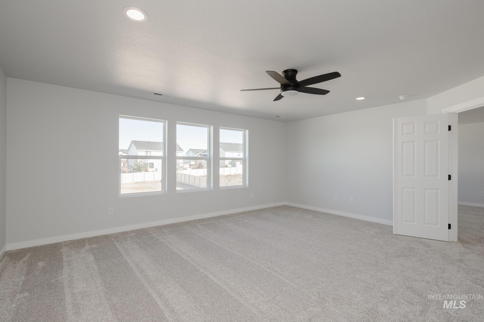 Empty room with light colored carpet, recessed lighting, and a ceiling fan