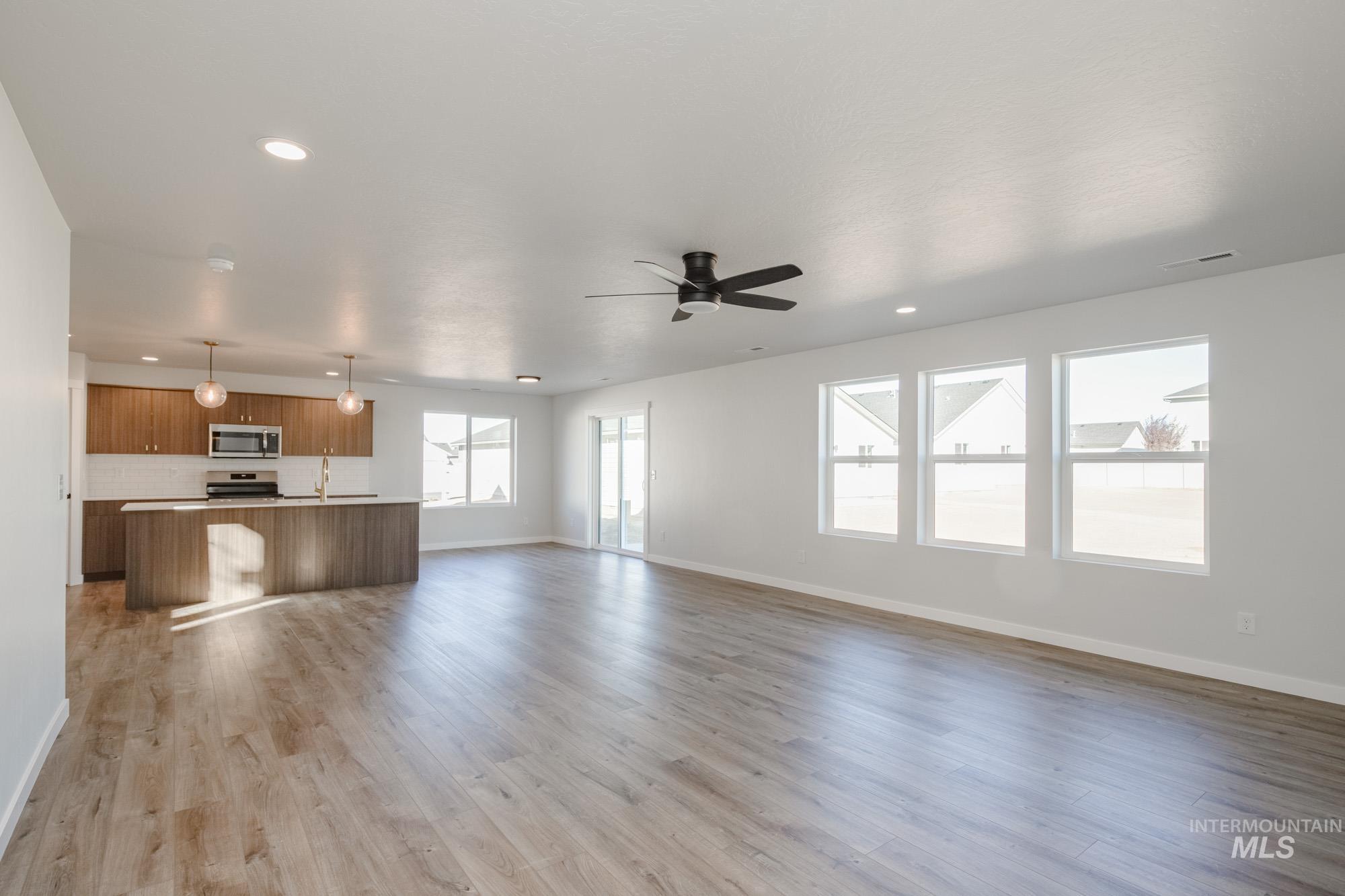 Unfurnished living room with light wood finished floors, recessed lighting, and a ceiling fan