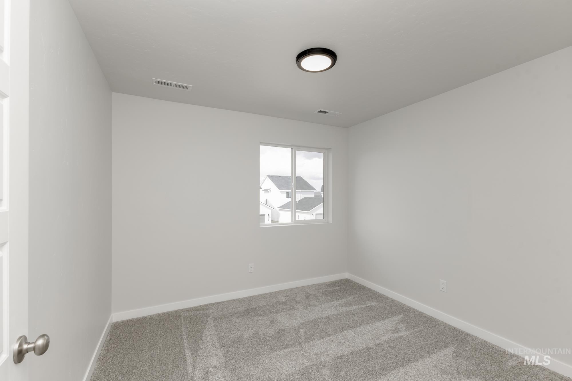 Empty room with carpet floors and baseboards