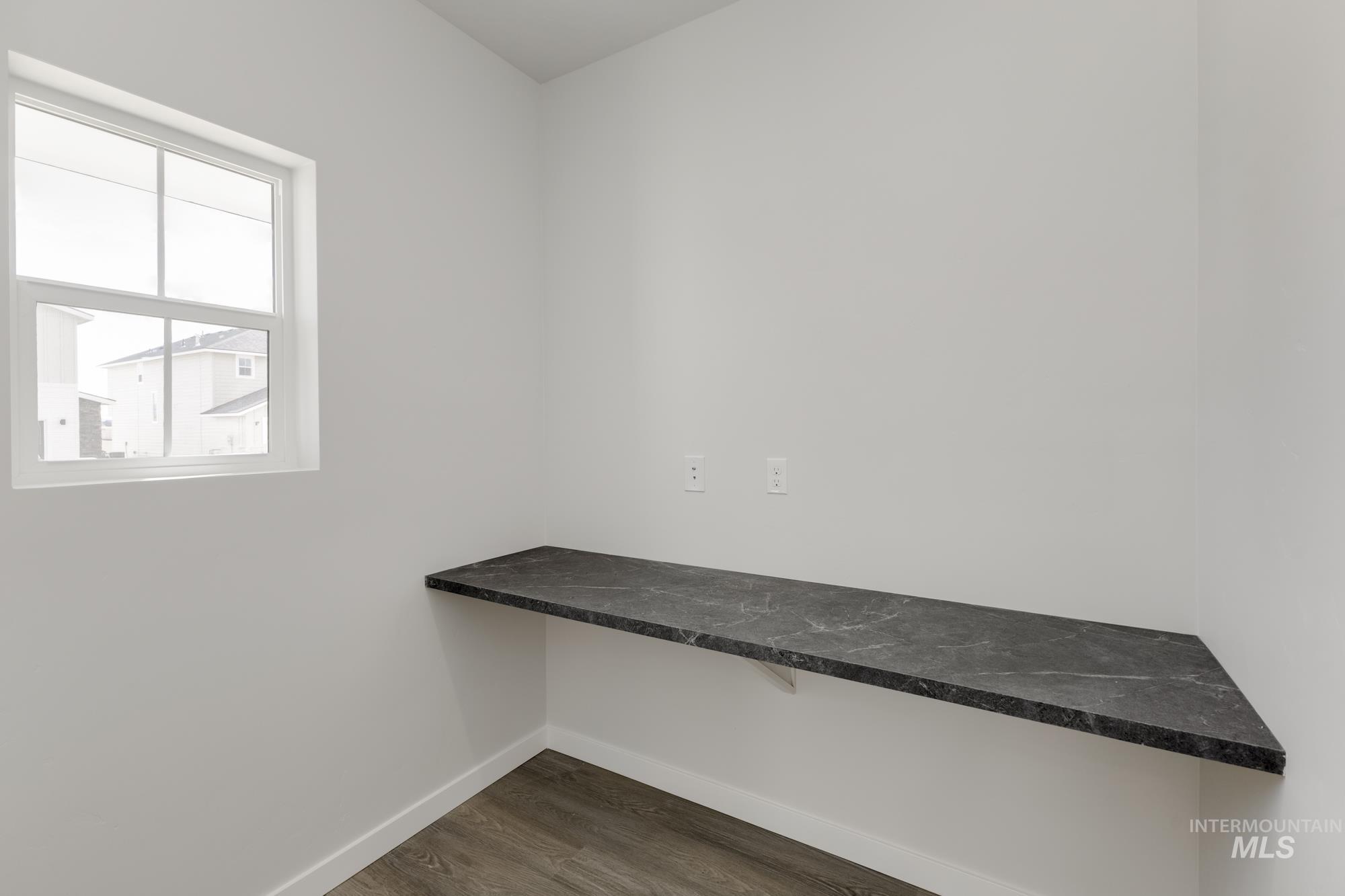 Unfurnished office with baseboards and dark wood-style flooring