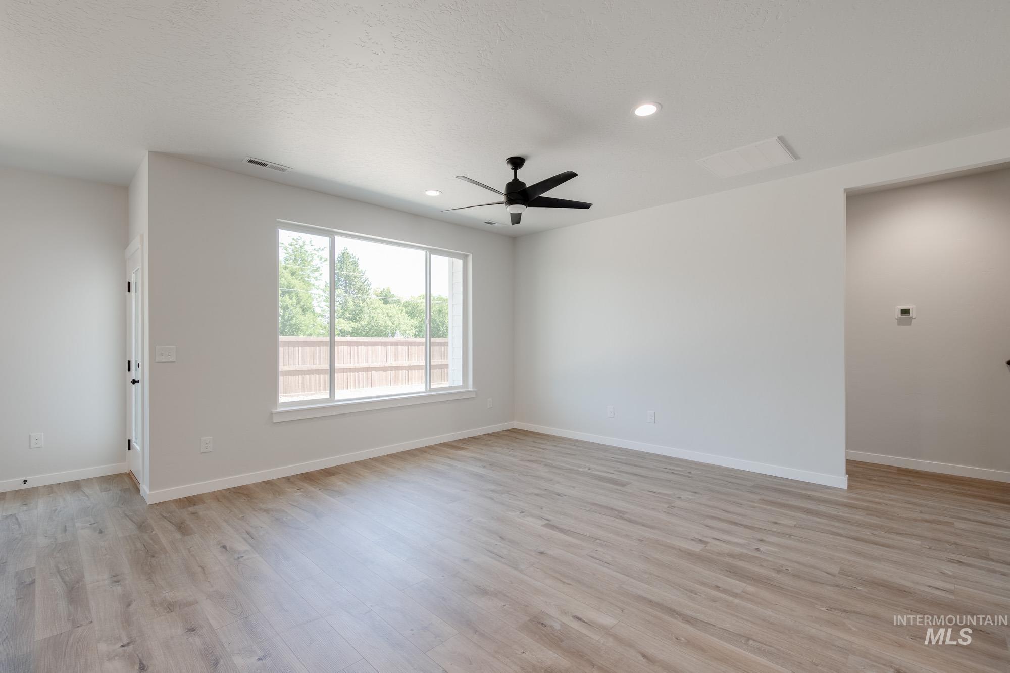 Unfurnished room featuring light wood-style floors, a ceiling fan, recessed lighting, and a textured ceiling