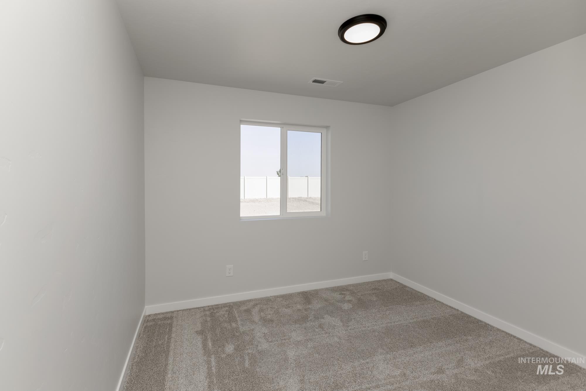 Unfurnished room with light colored carpet and baseboards