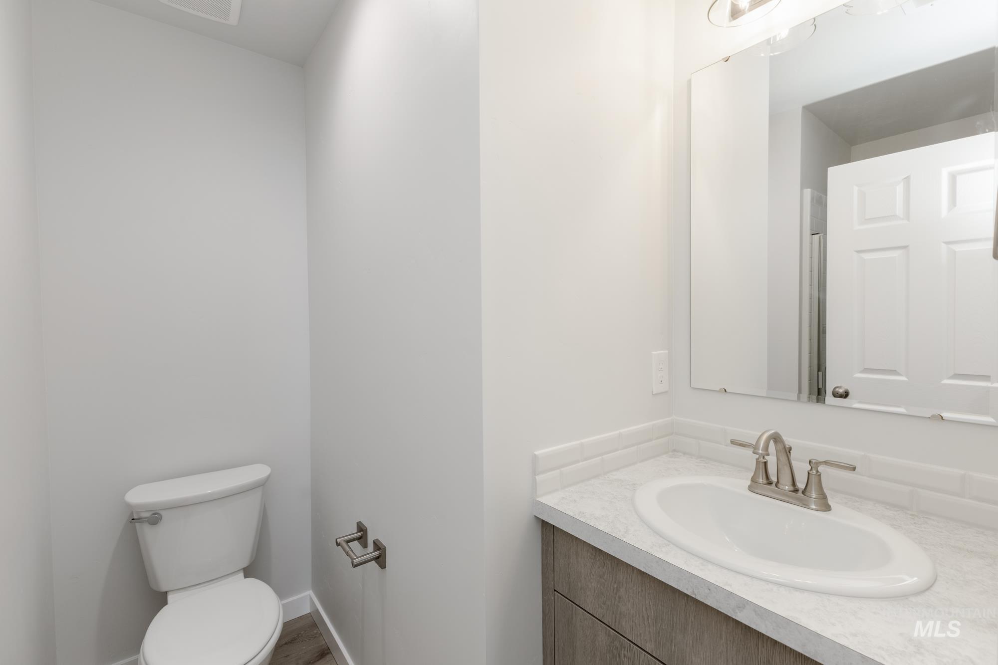 Half bathroom featuring vanity and toilet