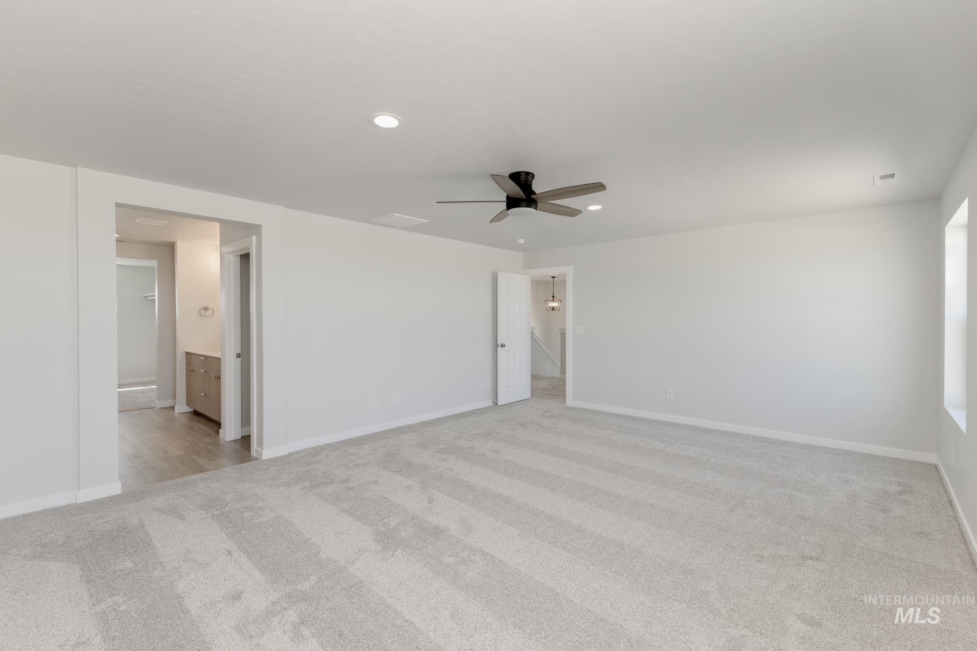 Empty room featuring light colored carpet, recessed lighting, and a ceiling fan
