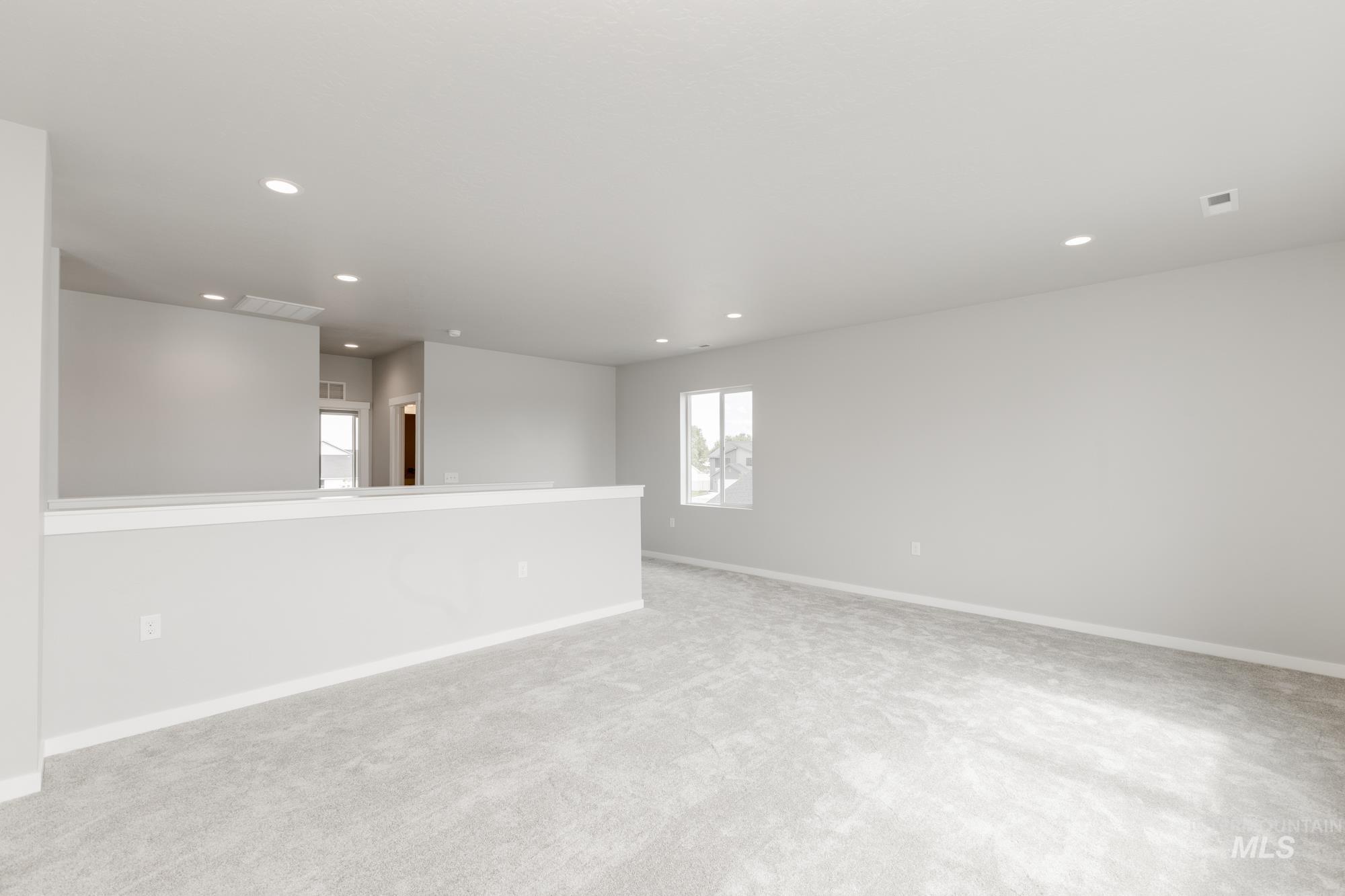 Empty room featuring light carpet and recessed lighting