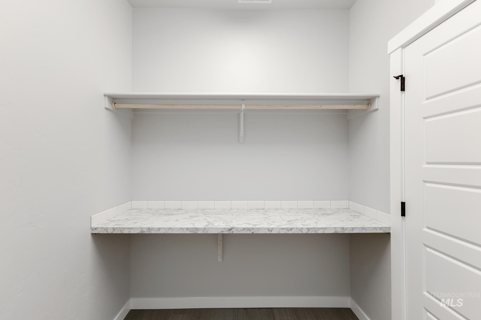 Spacious closet with dark wood-style flooring