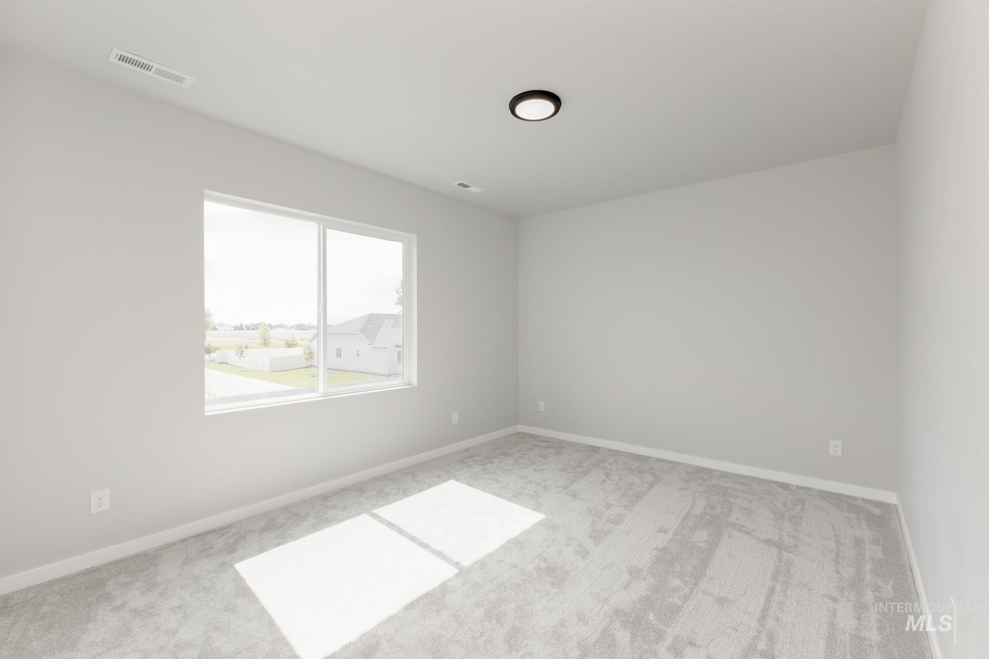 Empty room featuring light colored carpet