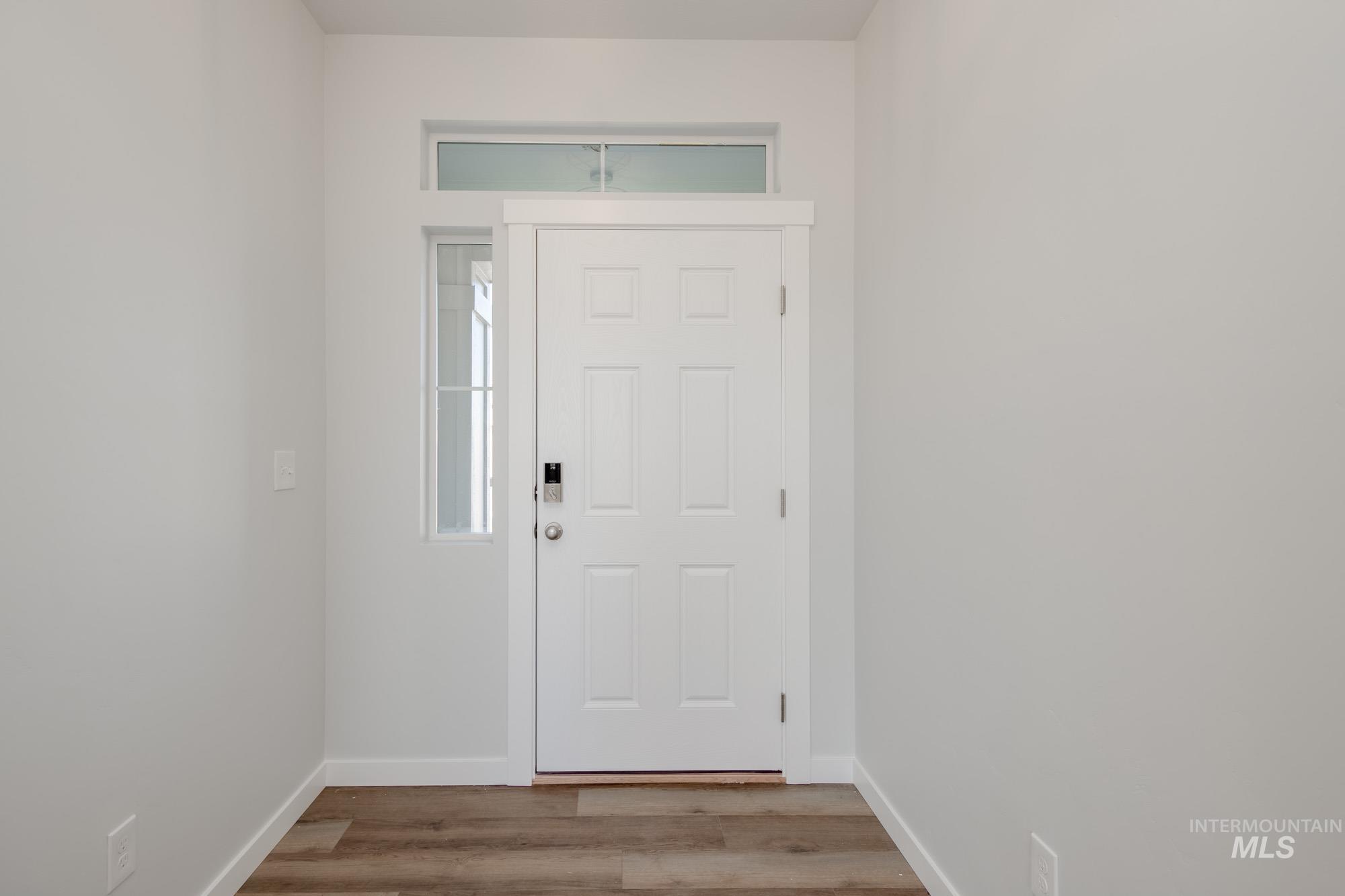 Entryway with wood finished floors and baseboards