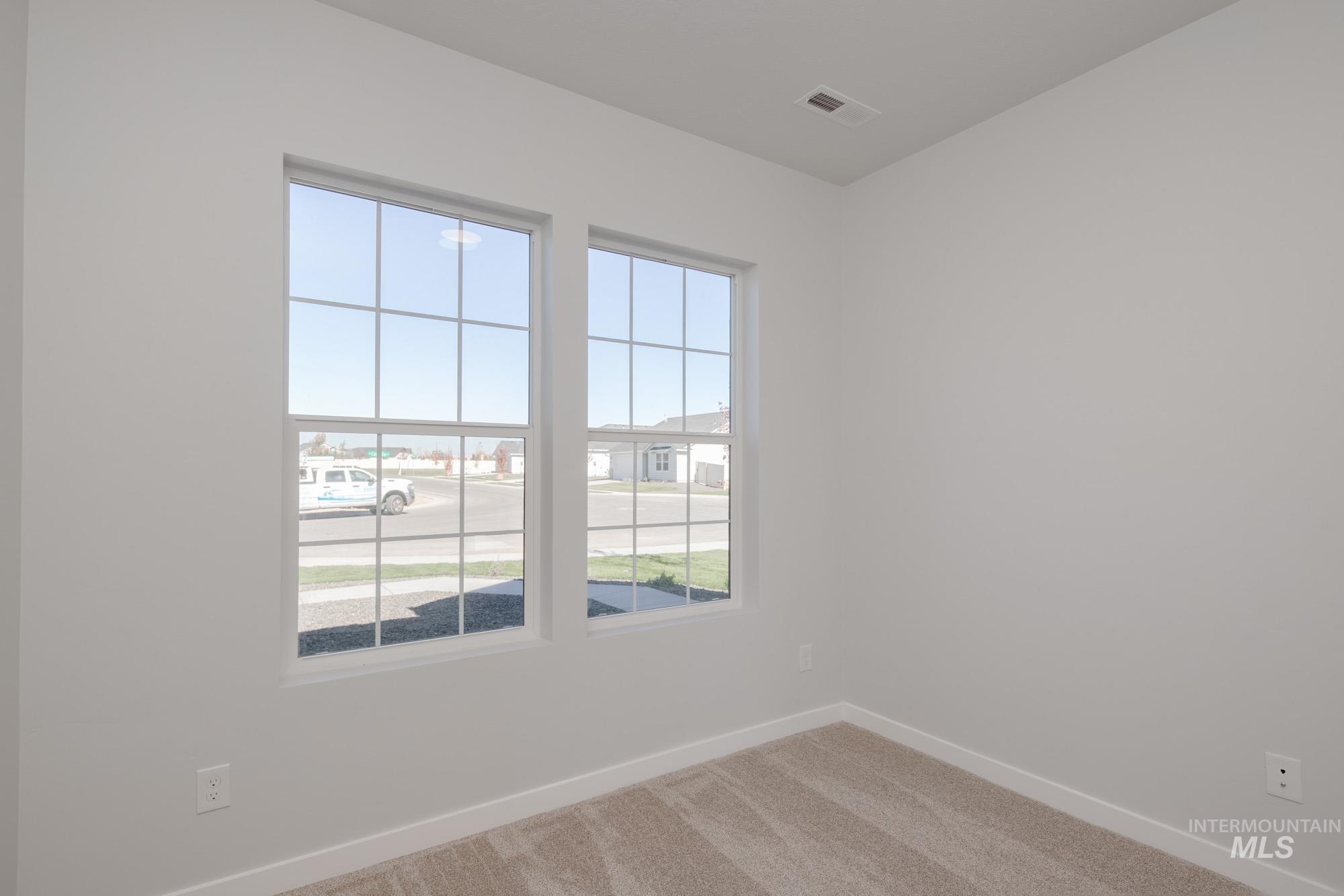 Unfurnished room featuring light carpet and baseboards