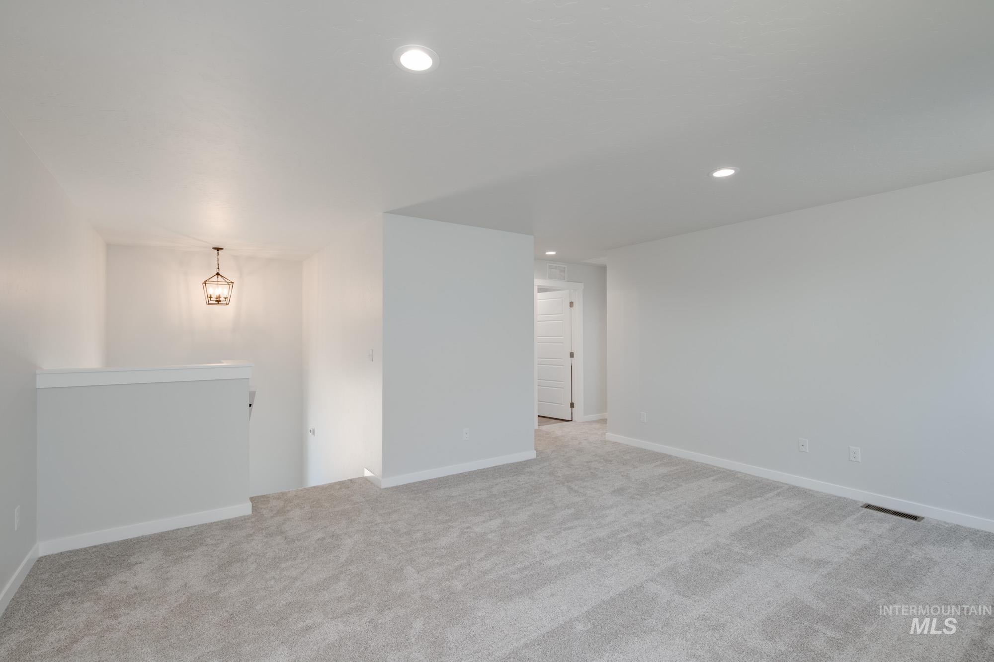 Spare room with light colored carpet and recessed lighting