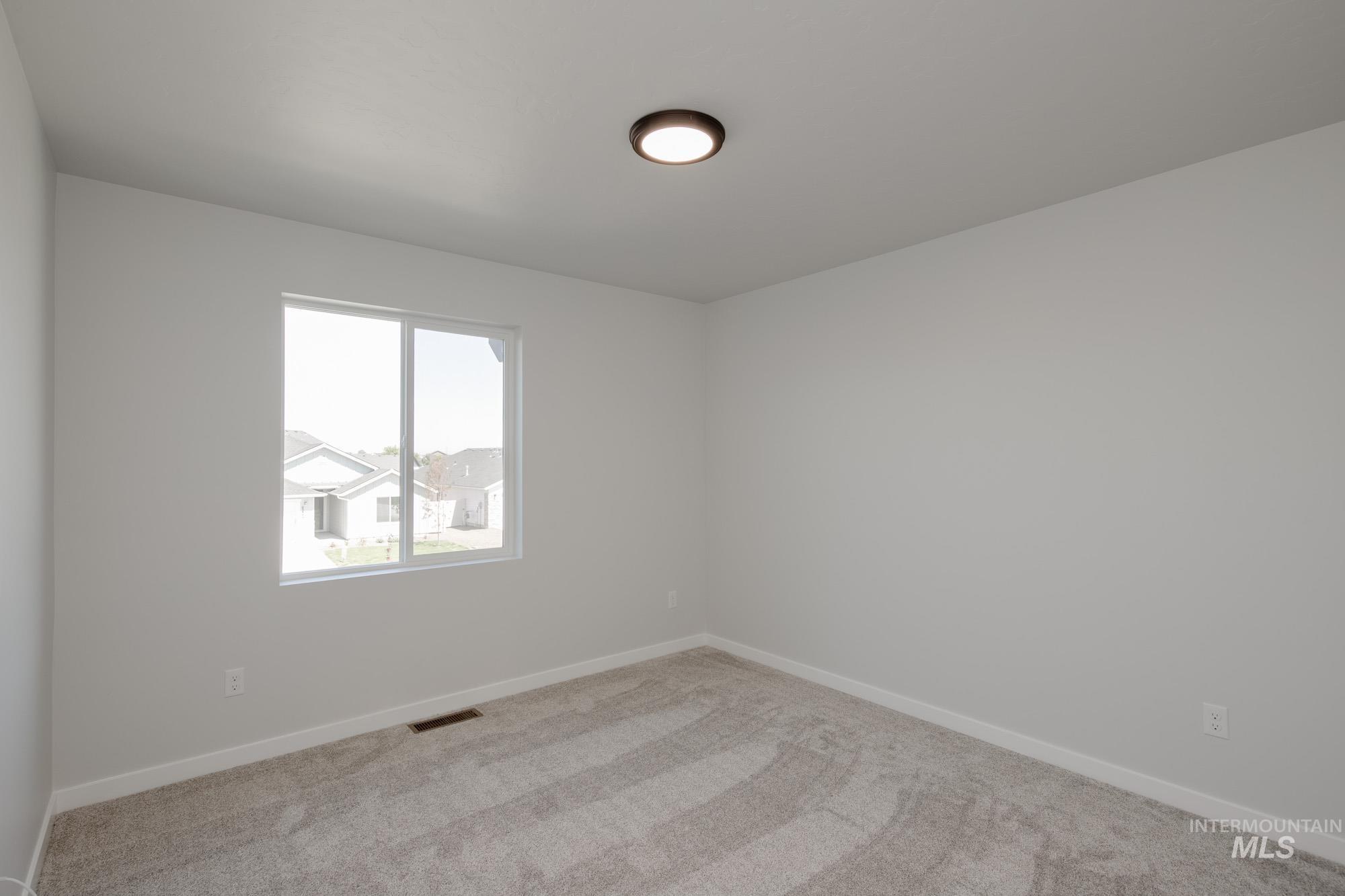 Spare room with baseboards and light carpet