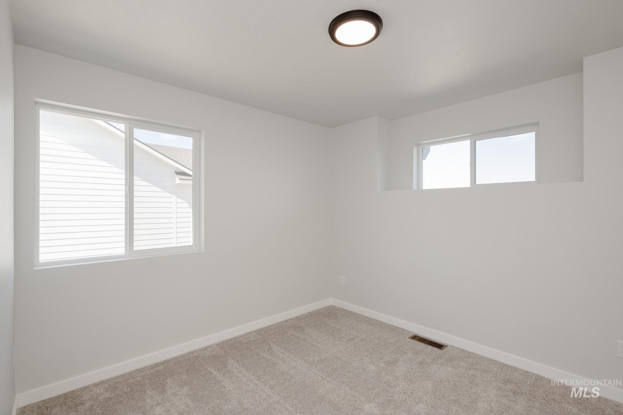 Empty room featuring carpet floors and baseboards