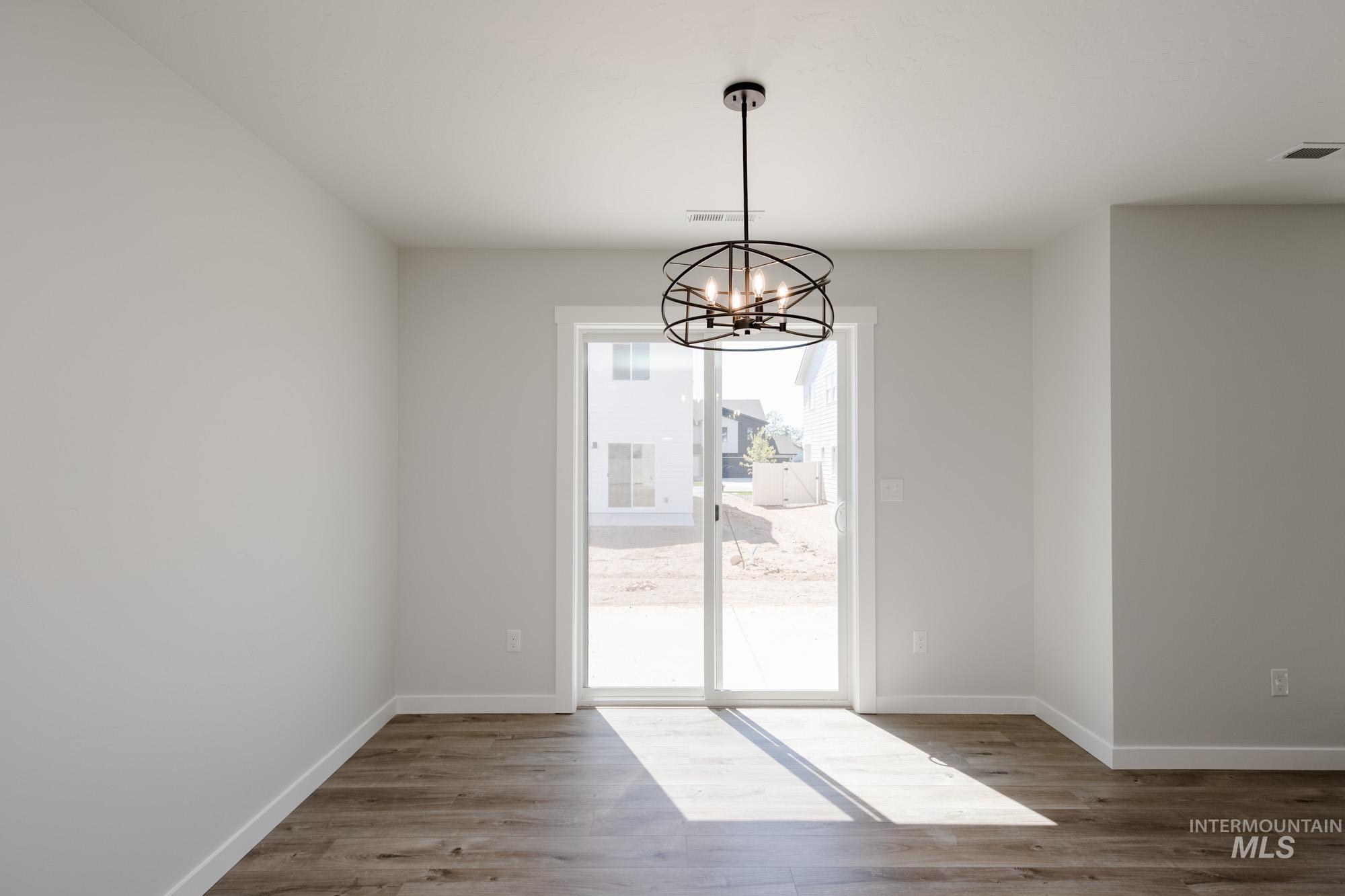Unfurnished dining area featuring light wood-style floors and a chandelier