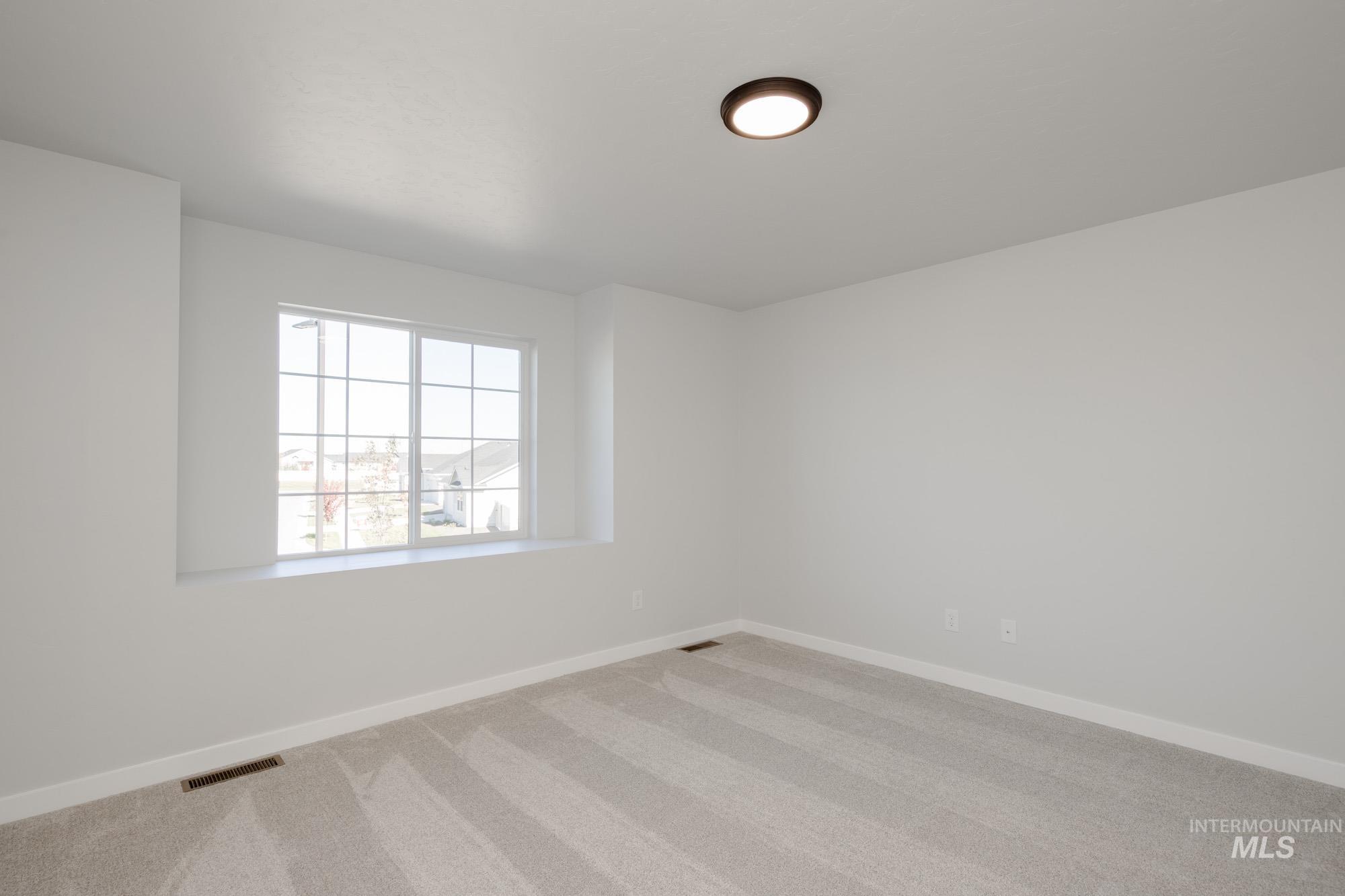 Carpeted empty room with baseboards