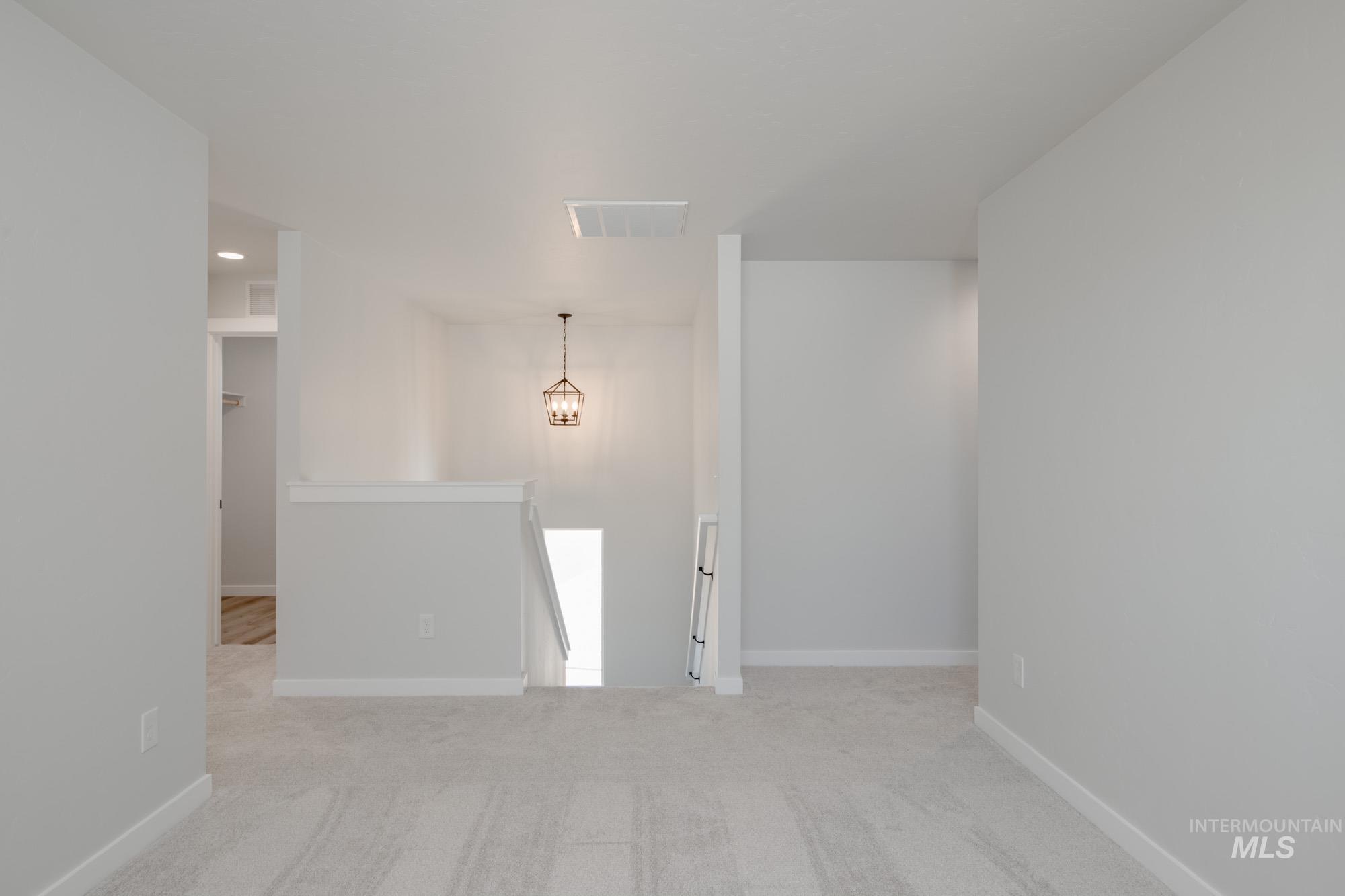 Empty room with light carpet and baseboards