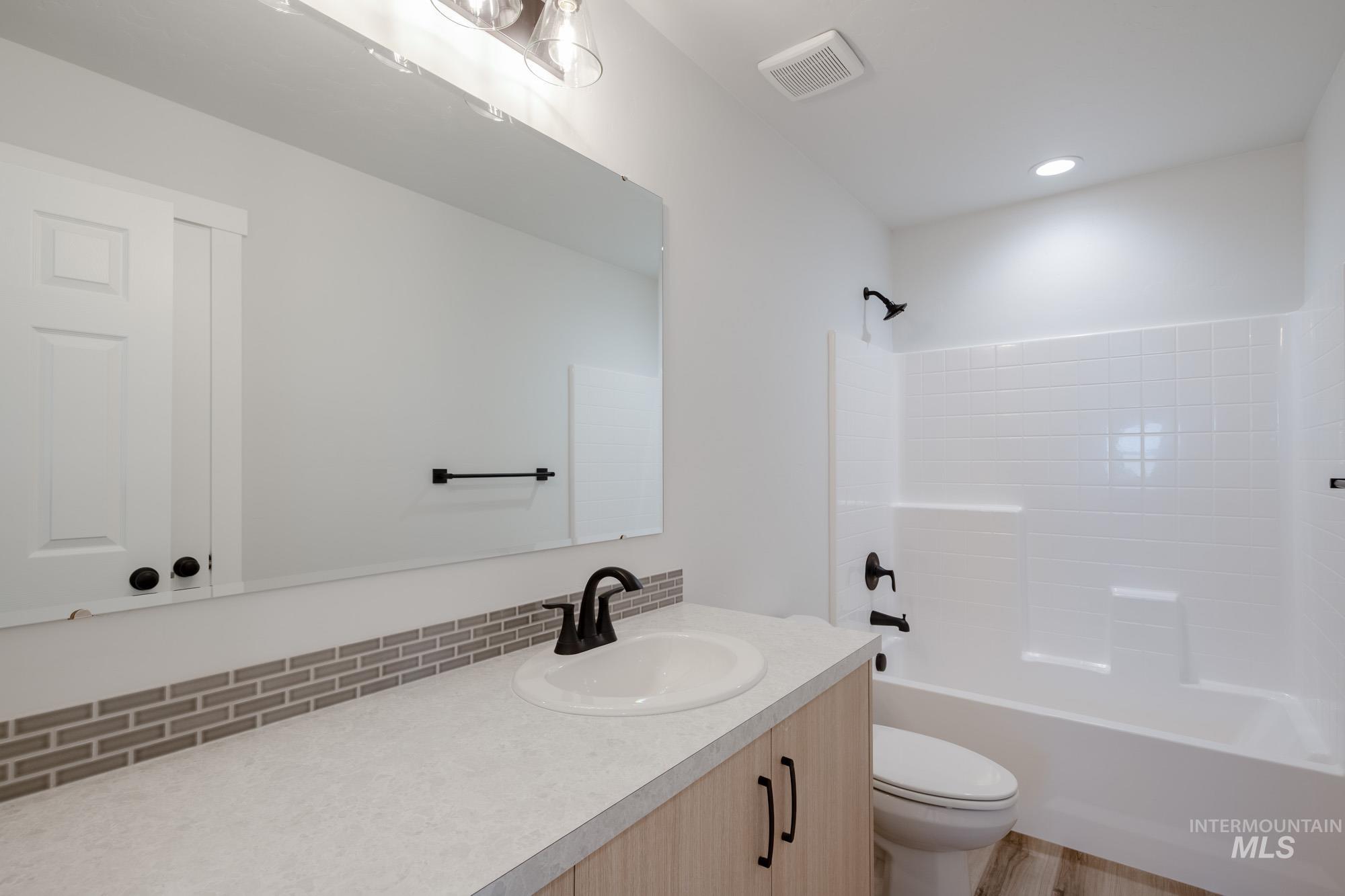 Bathroom with vanity, shower / washtub combination, and recessed lighting