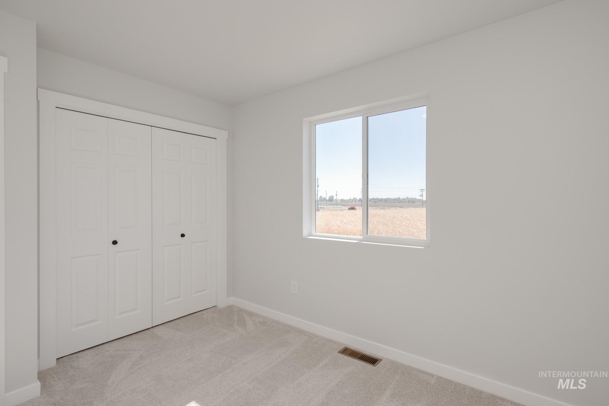 Unfurnished bedroom featuring light carpet and a closet