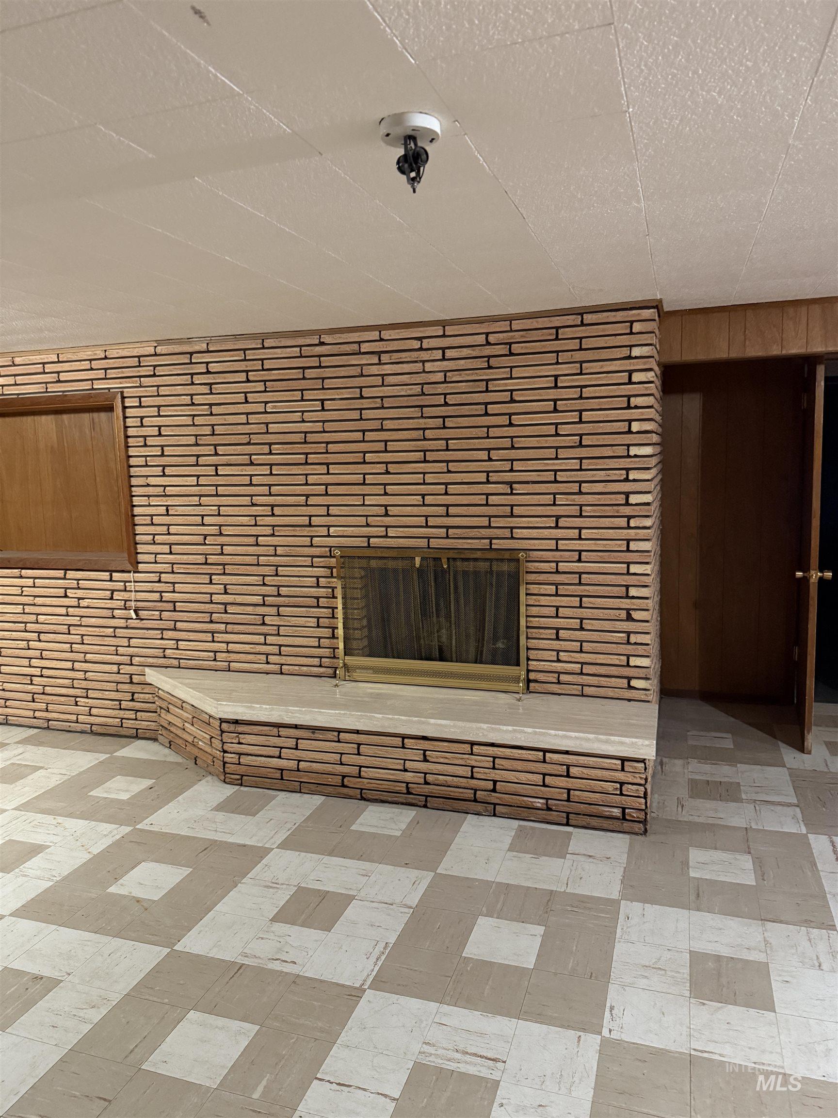 Detailed view of wooden walls, a fireplace, and a security system