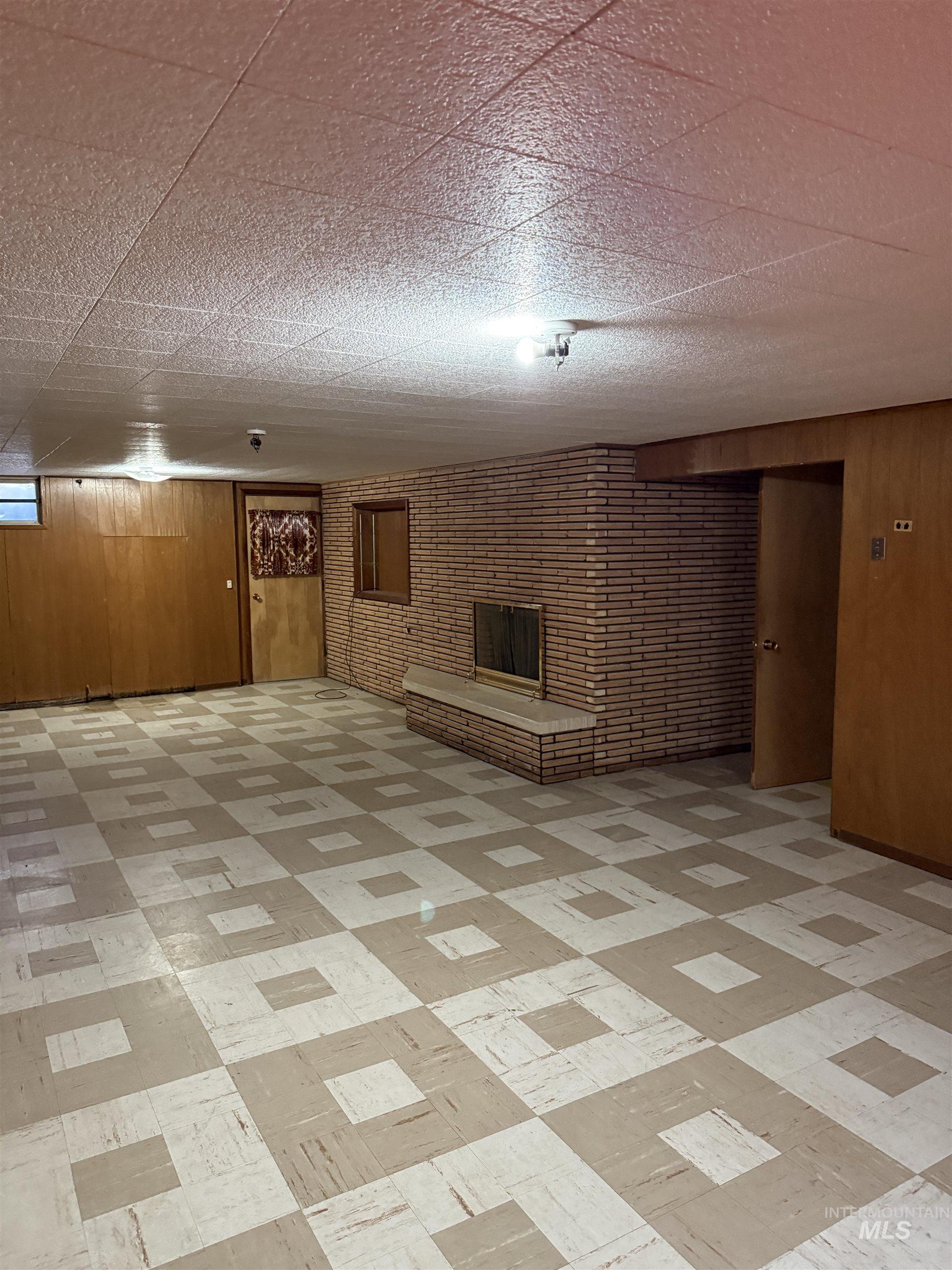 Basement with wood walls and light flooring