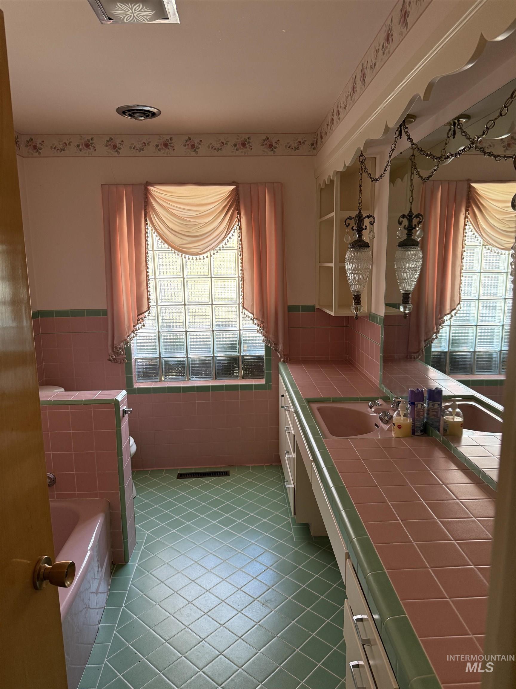 Kitchen with tile countertops, plenty of natural light, light tile patterned floors, tile walls, and open shelves