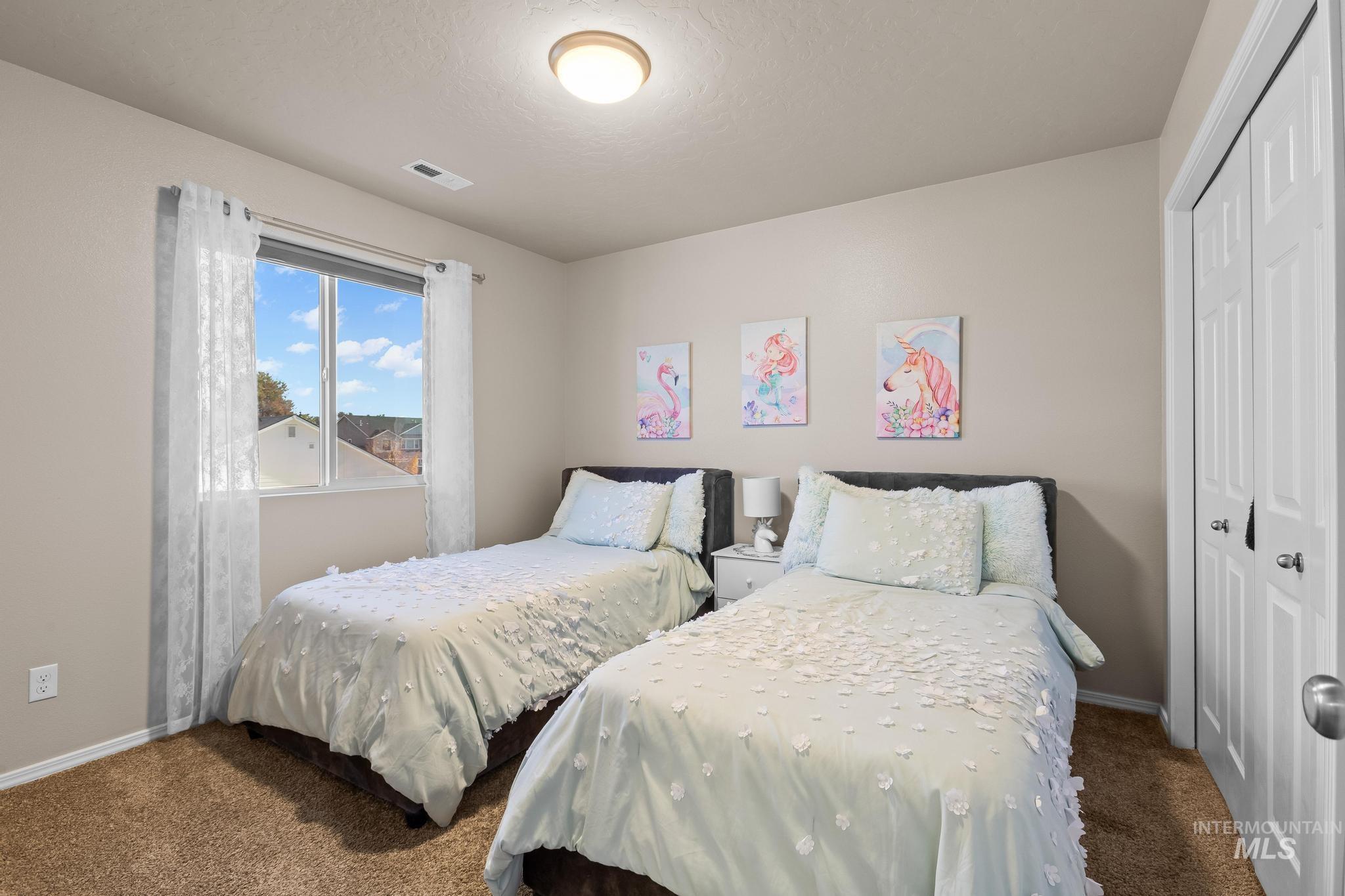 Bedroom with carpet floors, a closet, and a textured ceiling