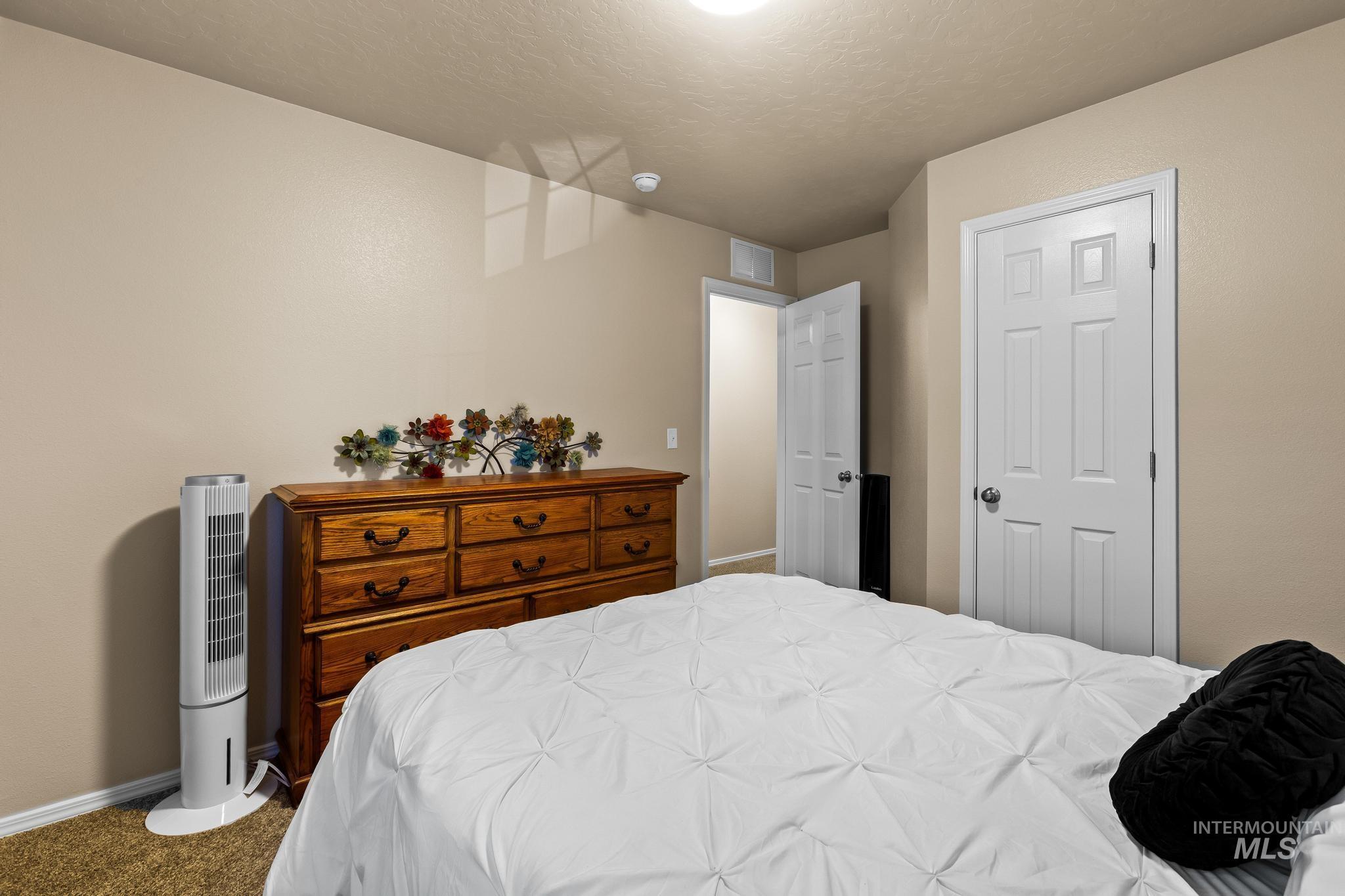 Carpeted bedroom with baseboards and a textured ceiling