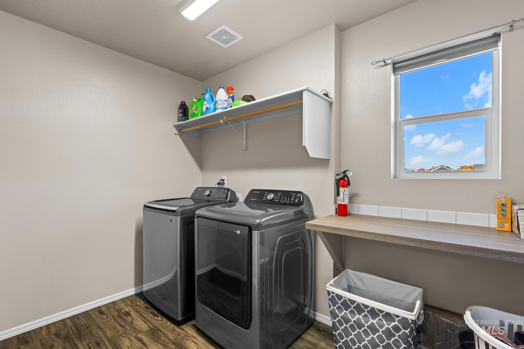 Washroom featuring dark wood-style floors and separate washer and dryer