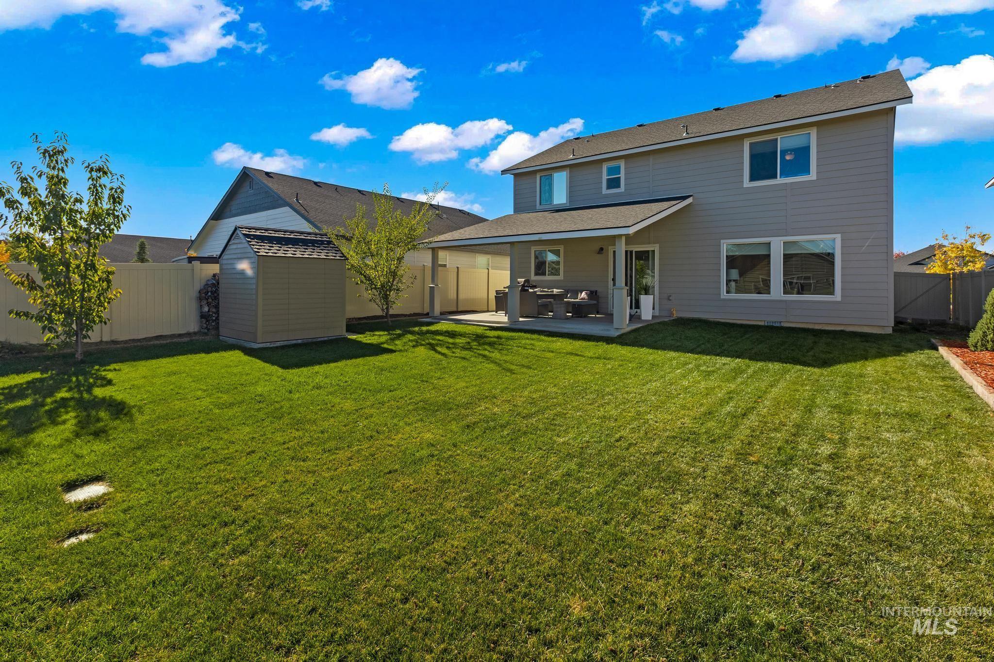 Rear view of house with a patio area, a fenced backyard, and a storage shed