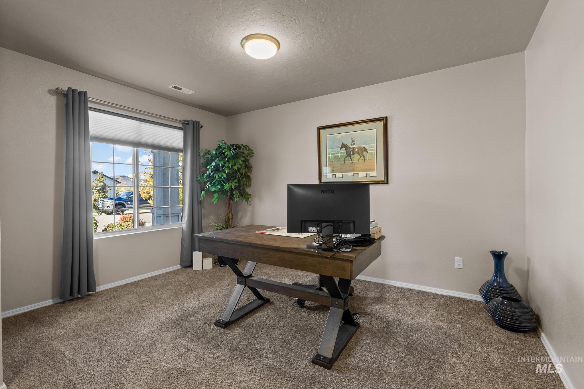 Office space with carpet and a textured ceiling