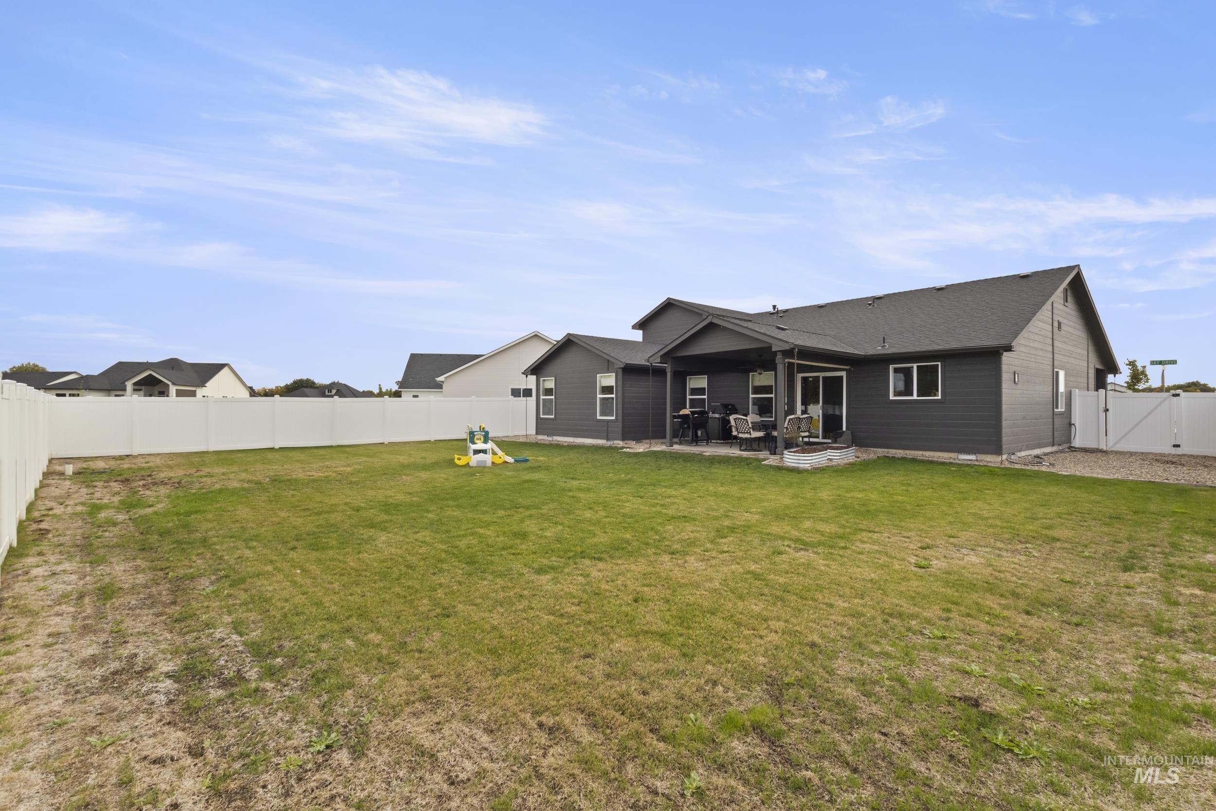 Back of property with a fenced backyard, a patio, and a gate