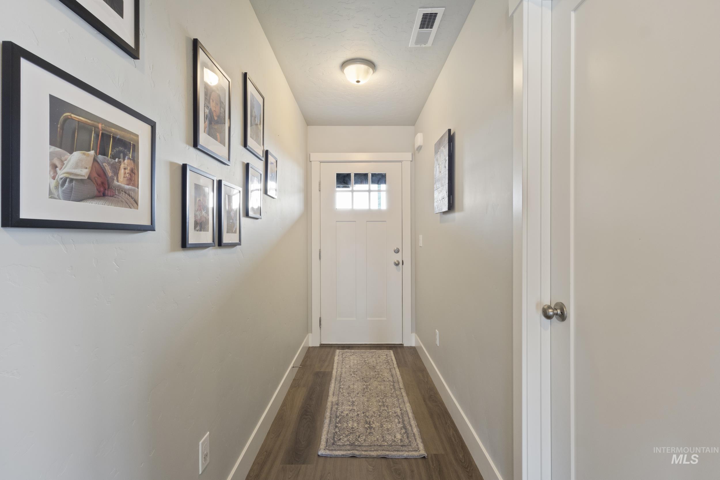 Entryway with baseboards and wood finished floors