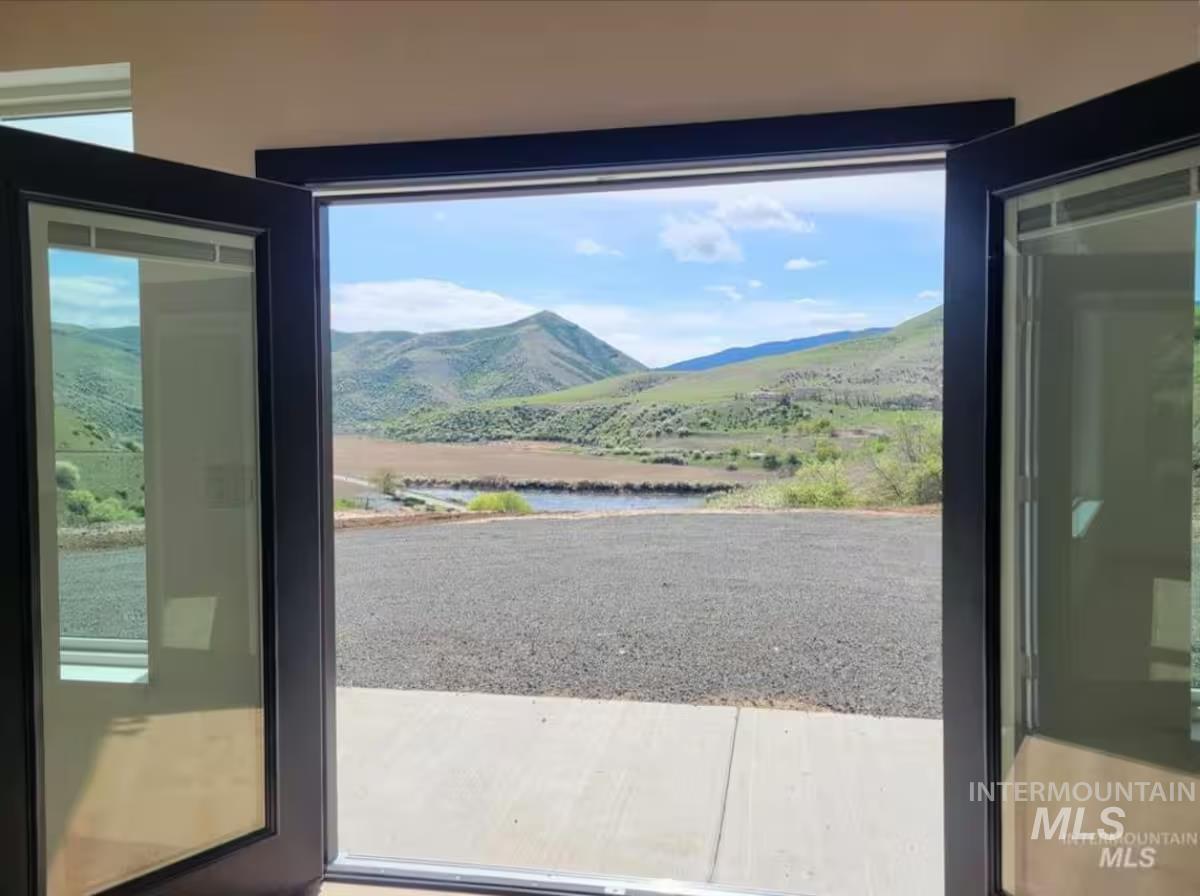 Doorway to outside featuring a water and mountain view