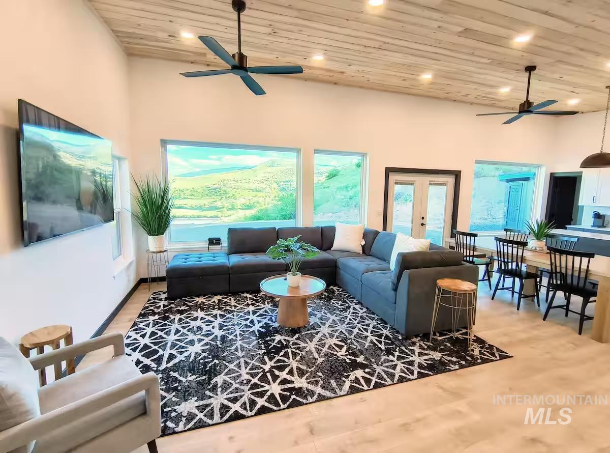 Living room featuring wooden ceiling, light wood-style floors, ceiling fan, recessed lighting, and french doors