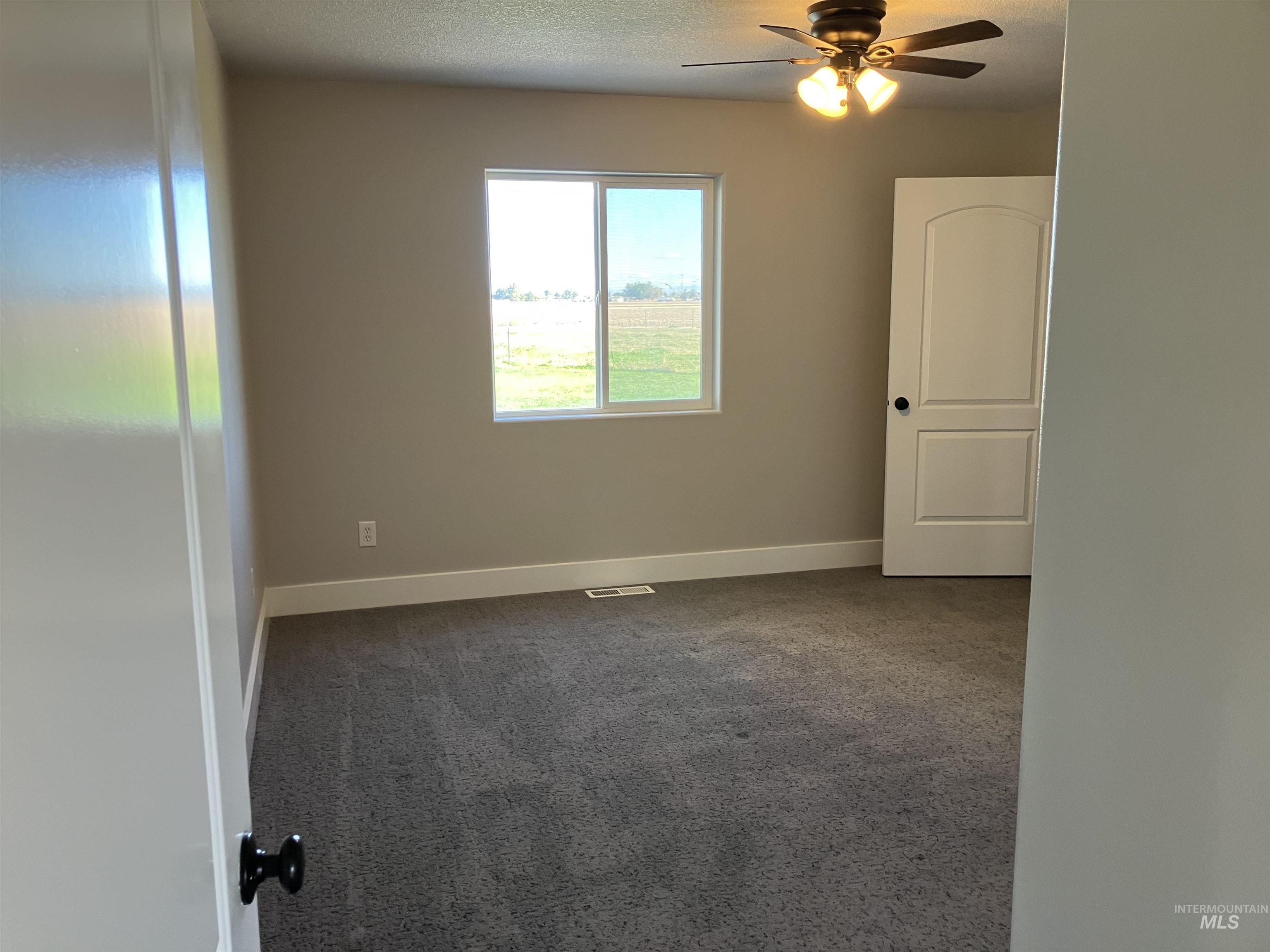 Master Bedroom with dark carpet, a textured ceiling, and ceiling fan