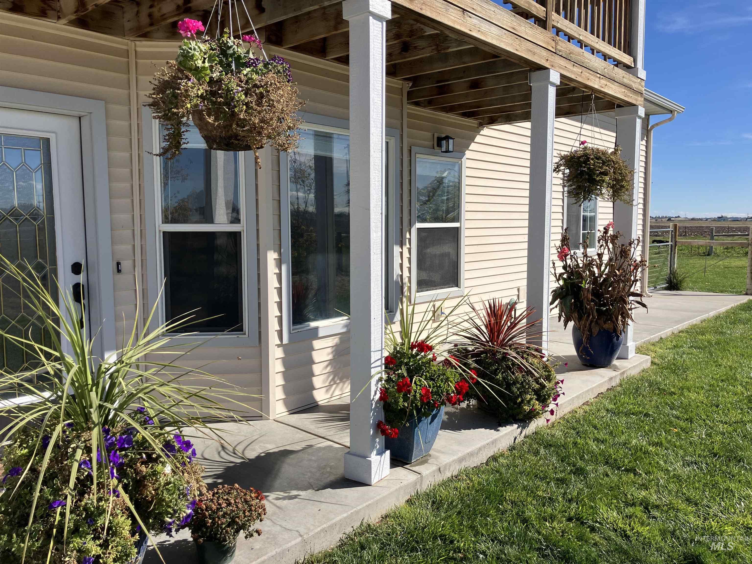 View of exterior entry featuring a yard and flowers